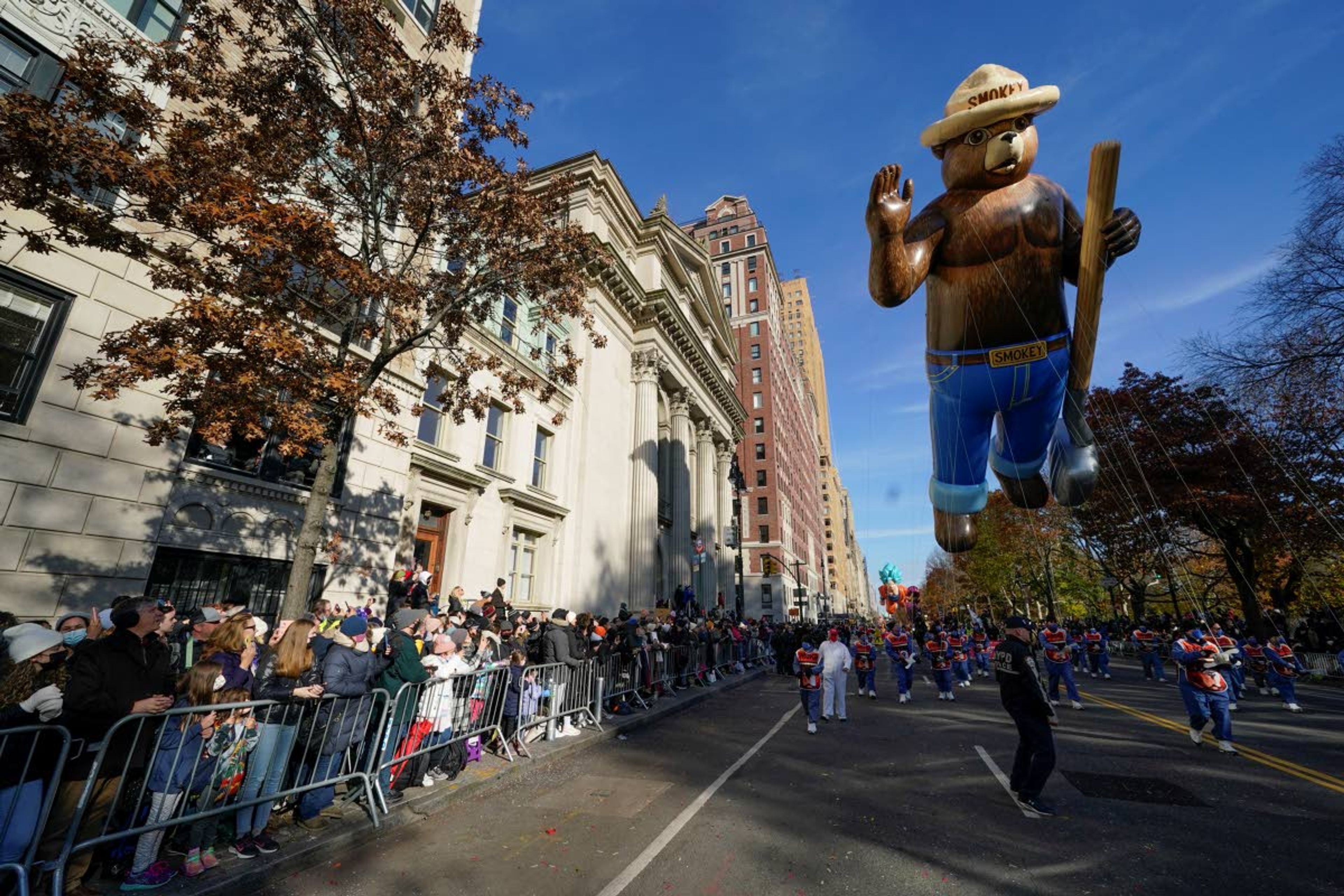 People watch as the Smokey Bear balloon passes during the Macy's Thanksgiving Day Parade in New York, Thursday, Nov. 25, 2021. The parade is returning in full, after being crimped by the coronavirus pandemic last year. (AP Photo/Seth Wenig)