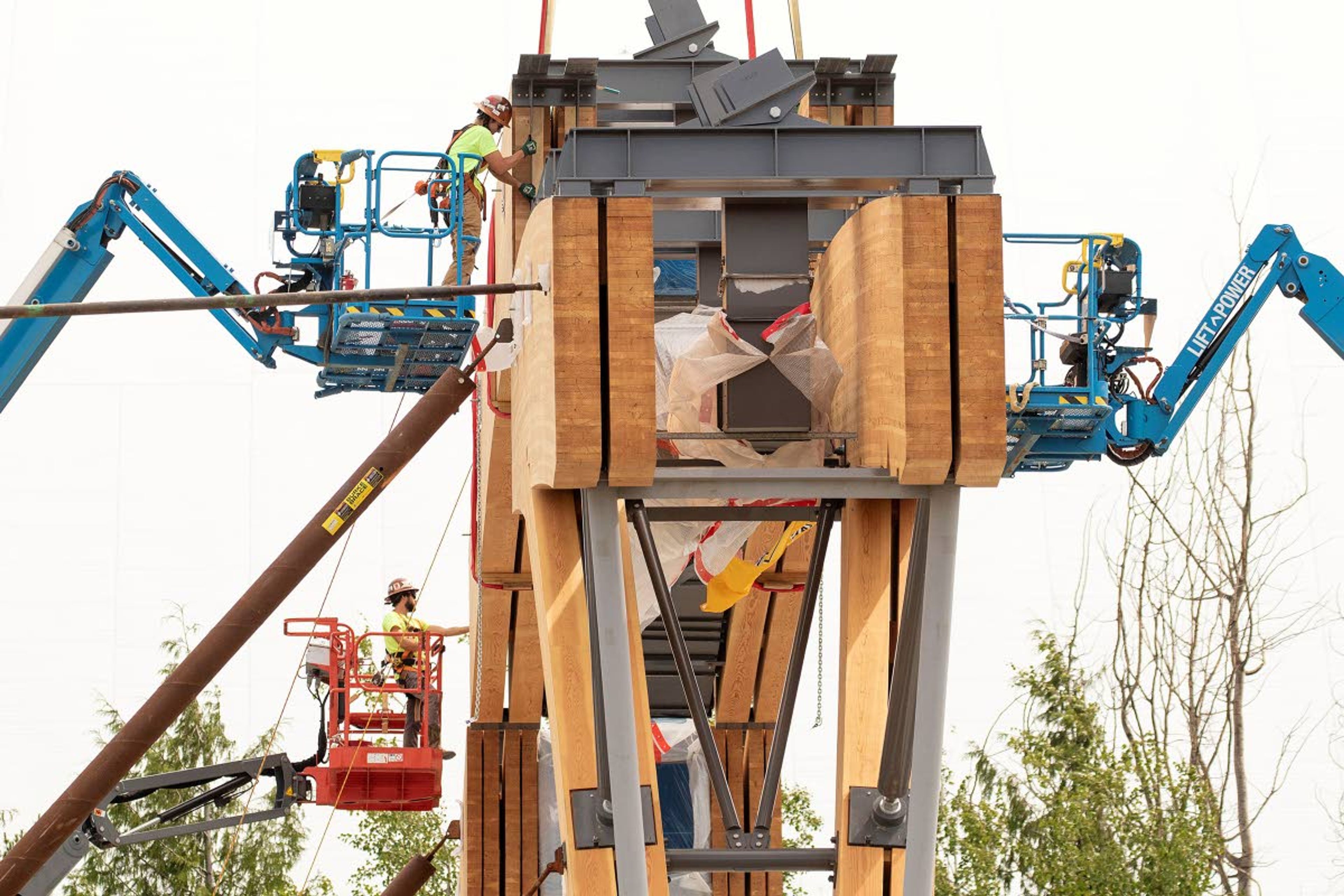 Workers secure a laminated wood beam after it was lifted into place with a crane on Wednesday at the Idaho Central Credit Union Arena at the University of Idaho in Moscow. The 60-foot-long beam weighs about 40,000 pounds. Arena construction is expected to be completed in September 2021.