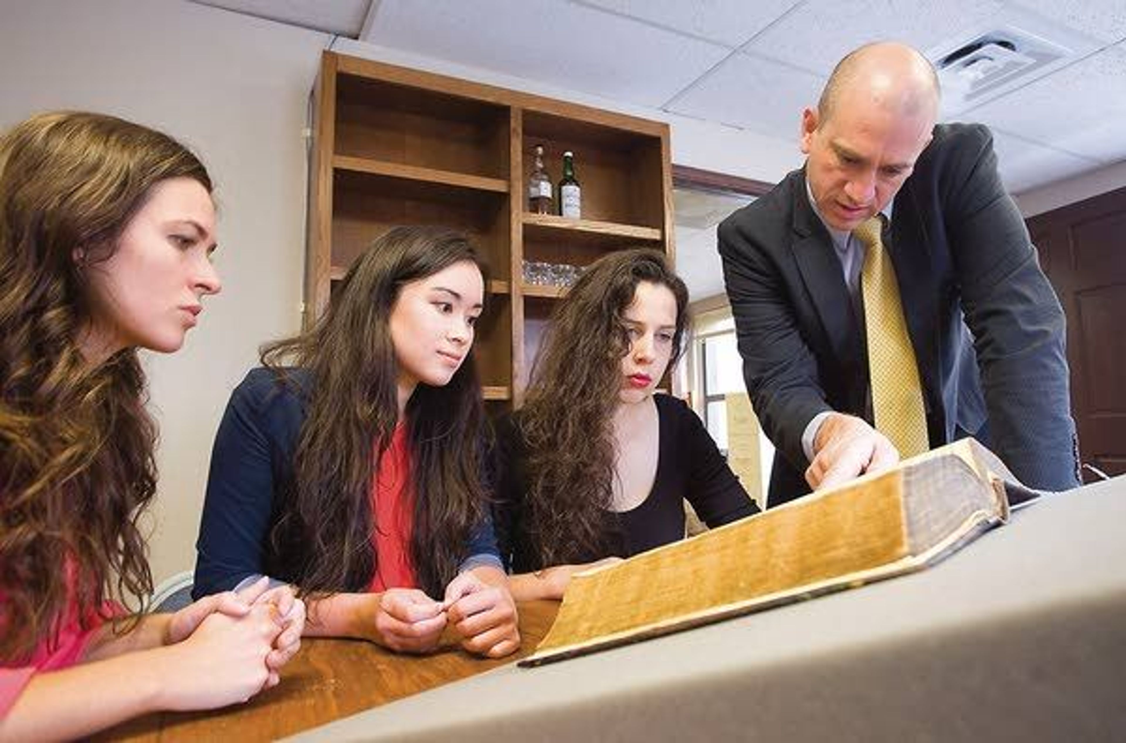 New Saint Andrews College’s new president, Ben Merkle, talks with students Angie Filicetti, left to right, Rachel Jo and Michelle Bollen about a 1593 Junius Tremellius Bible on Wednesday in Moscow.