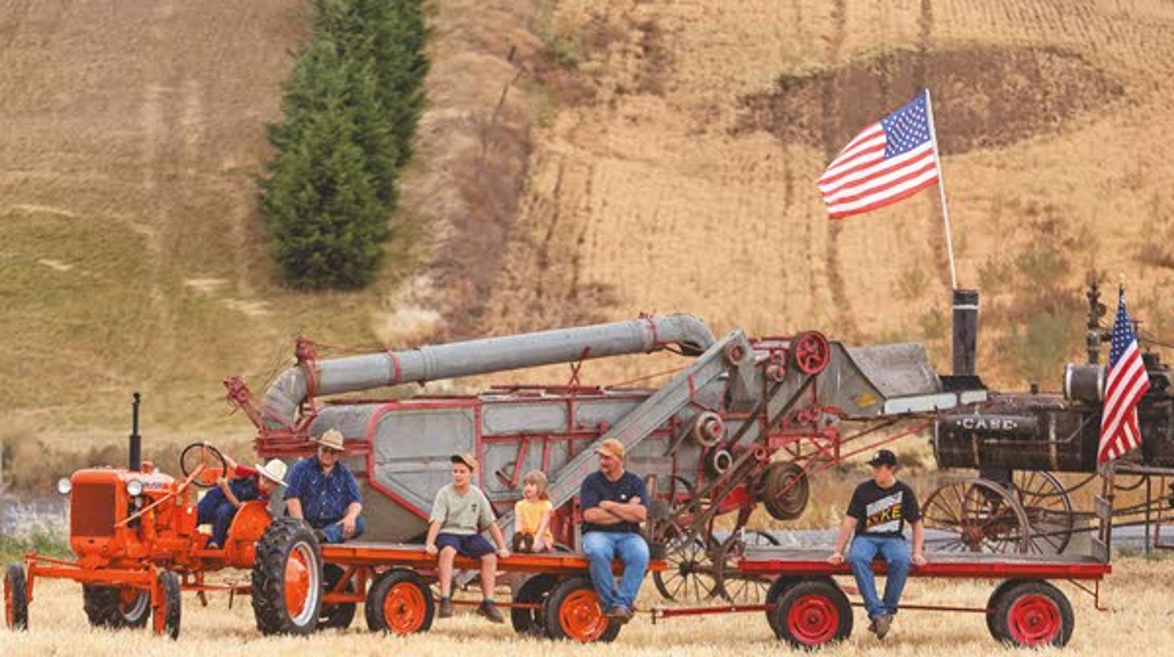 Jacob Lyle, left, leans into the turn as he drives tractor while giving tours of the rained-out annual Palouse Empire Threshing Bee on Monday, Sept. 2, 2013, outside the Palouse Empire Fairgrounds in Colfax.