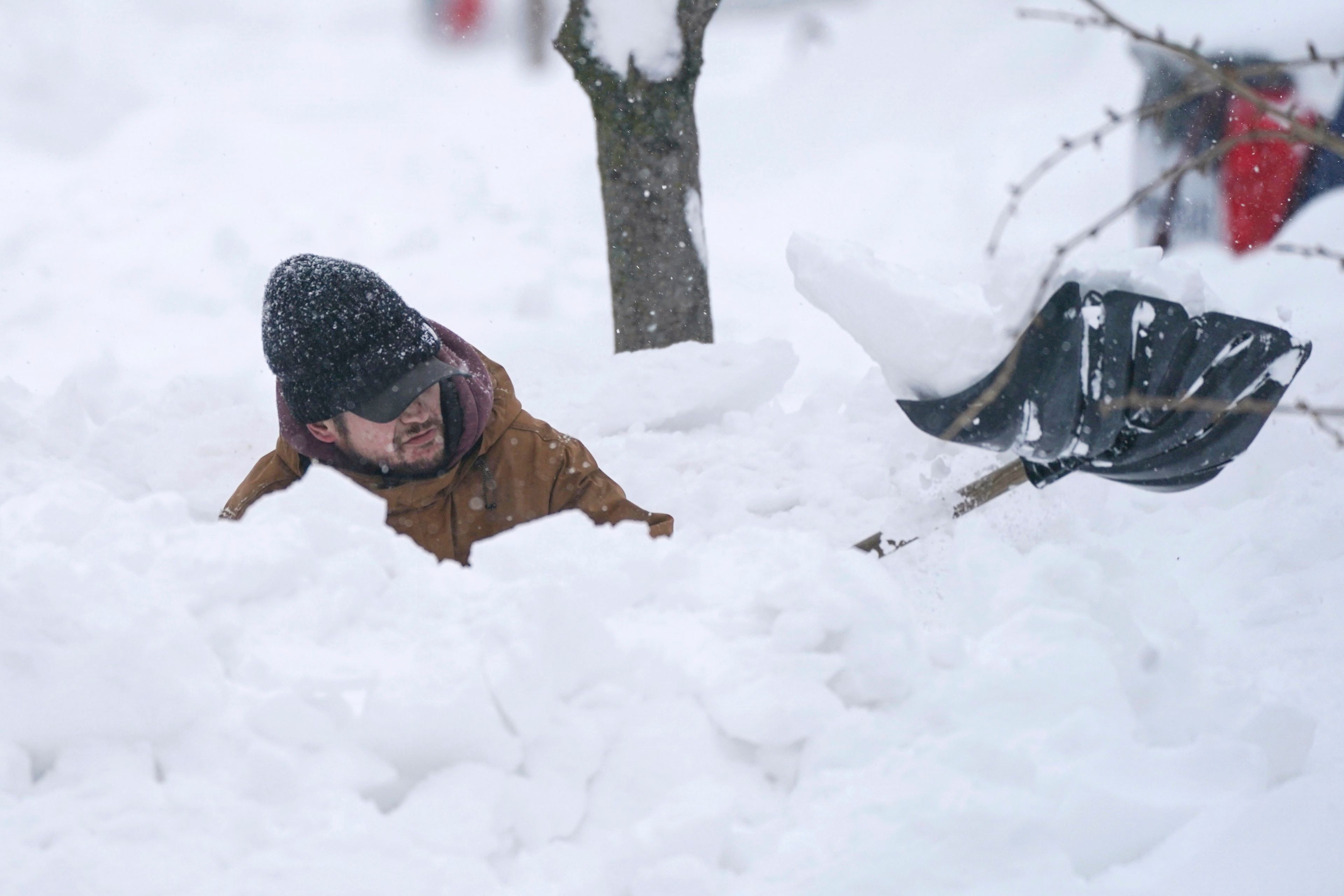 Tommy Roetzer digs out his driveway on West Delavan Street in Buffalo, N.Y., on Monday, Dec. 26, 2022. (Derek Gee/The Buffalo News via AP)