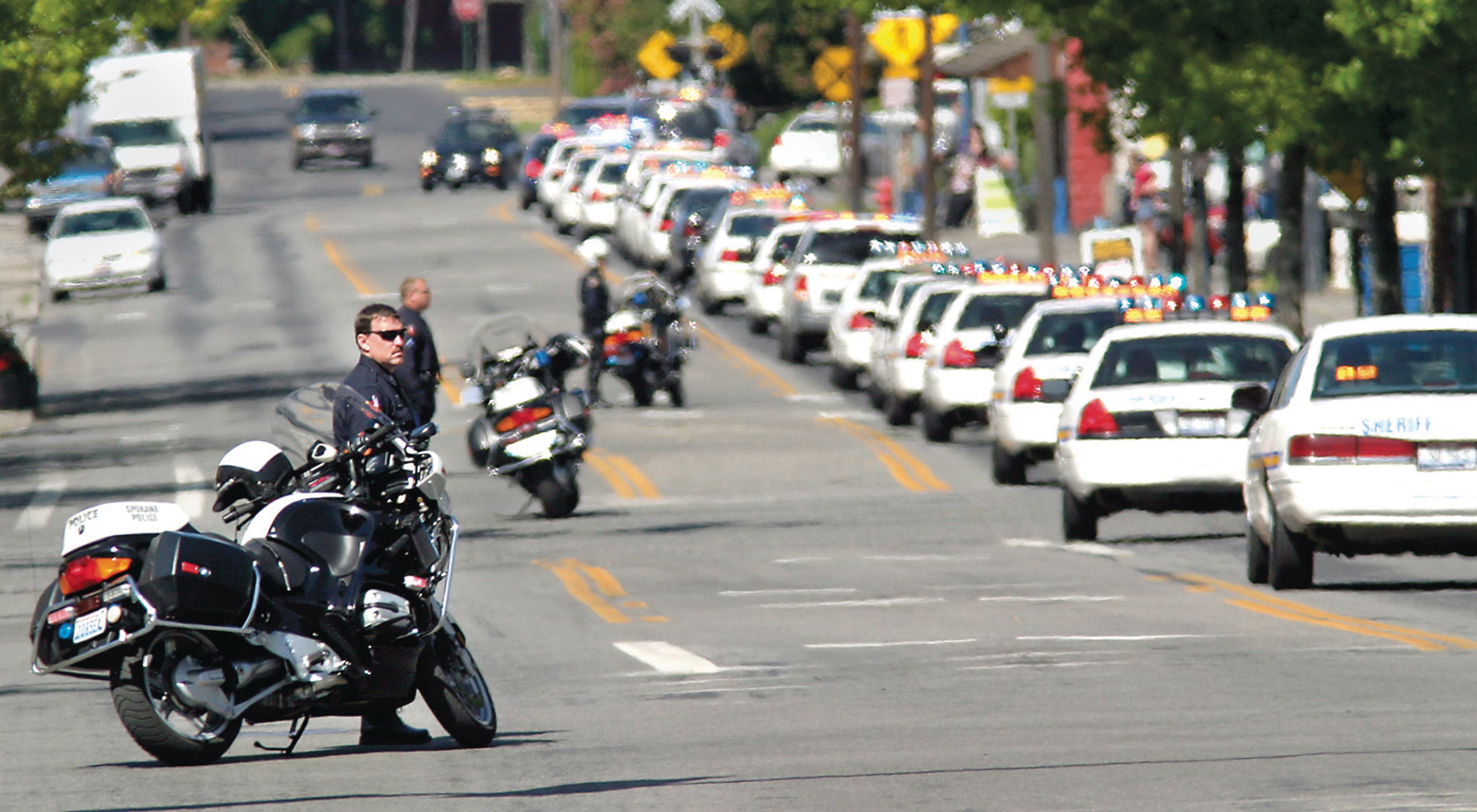 Motorcycle police officers block side streets May 25, 2007, while a funeral procession for Moscow police officer Lee Newbill travels down Third Street in downtown Moscow.