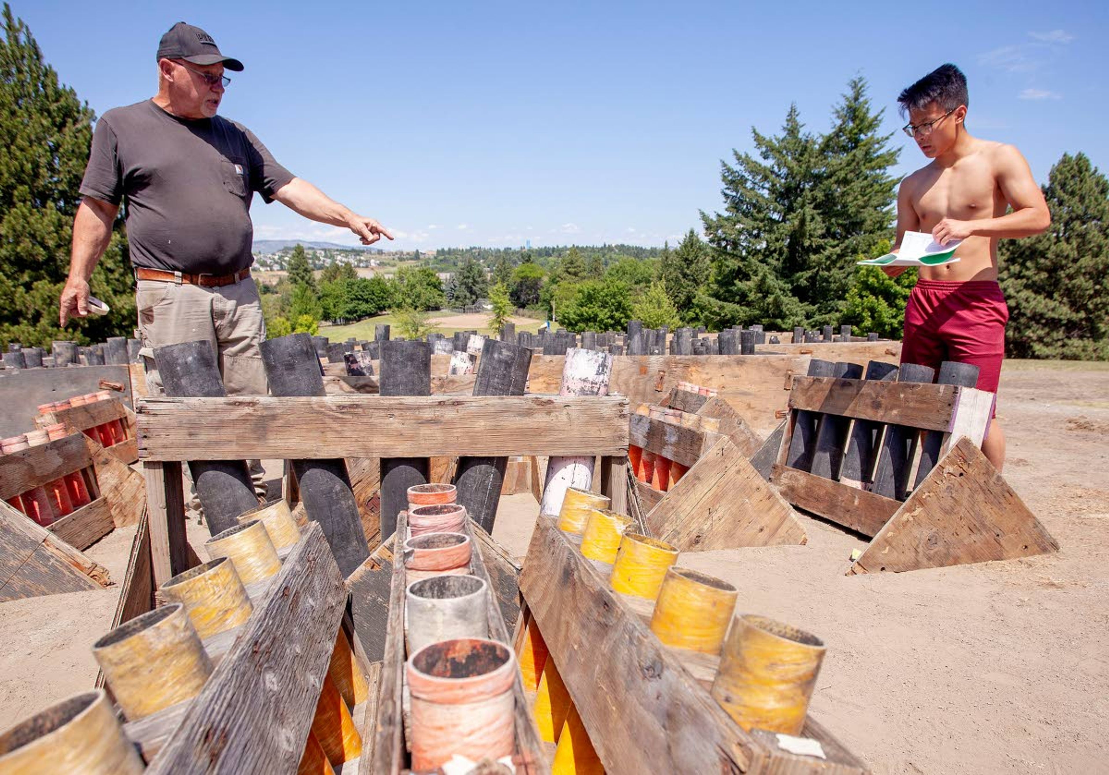 Geoff Crimmins/Daily NewsHead pyrotechnician Dave Wingo, left, and Peter Wang set up tubes for launching fireworks Monday at Sunnyside Park in Pullman. The men work for Pyro Spectaculars in Spokane.