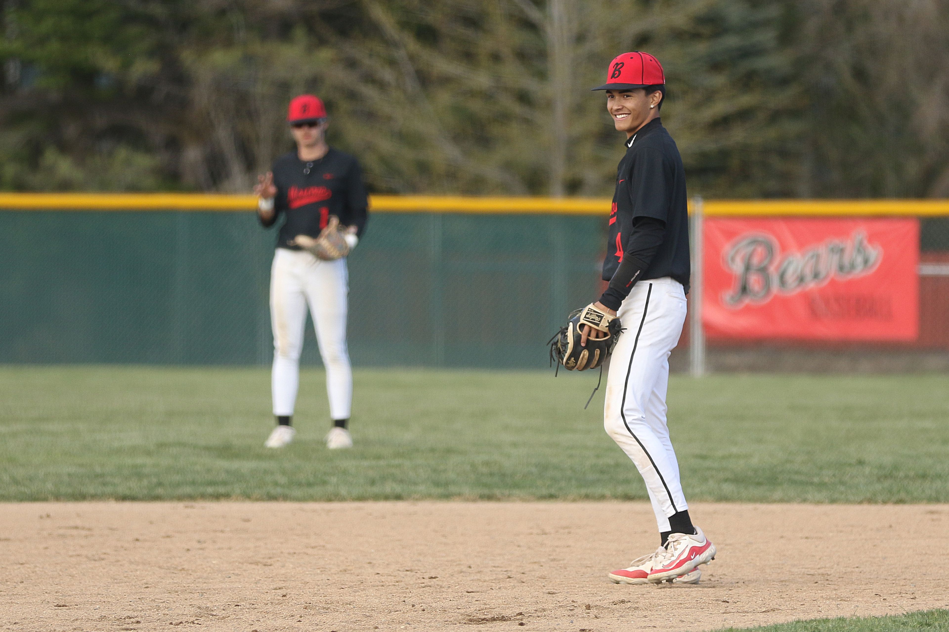 Moscow shortstop JP Breese (right) smiles between at-bats during an Idaho Class 4A district championship game against Sandpoint on Wednesday in Moscow.