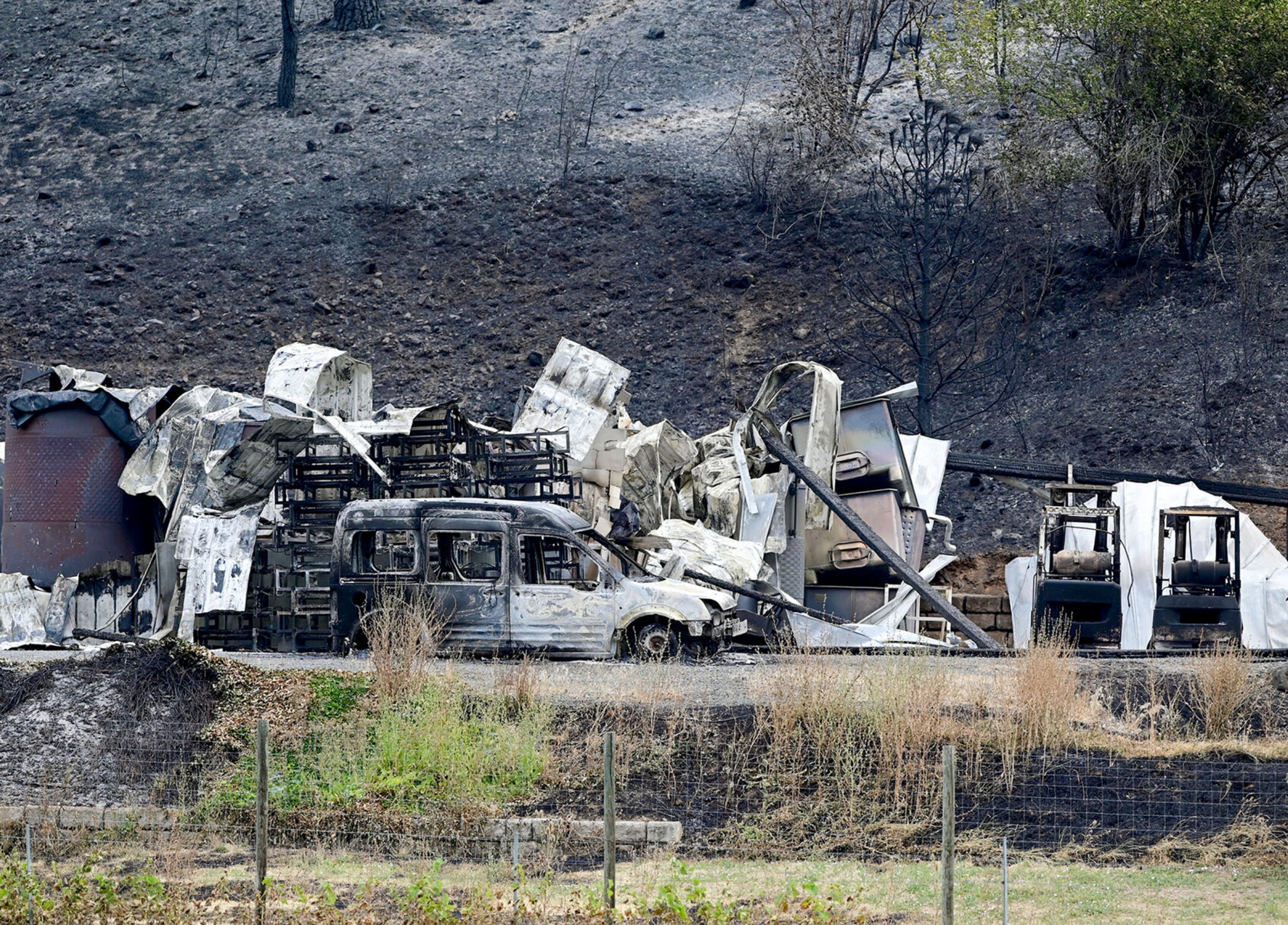 A van and other operational vehicles are visible on Monday in the remains of buildings at Colter’s Creek Winery, which burned down in the Gwen Fire.