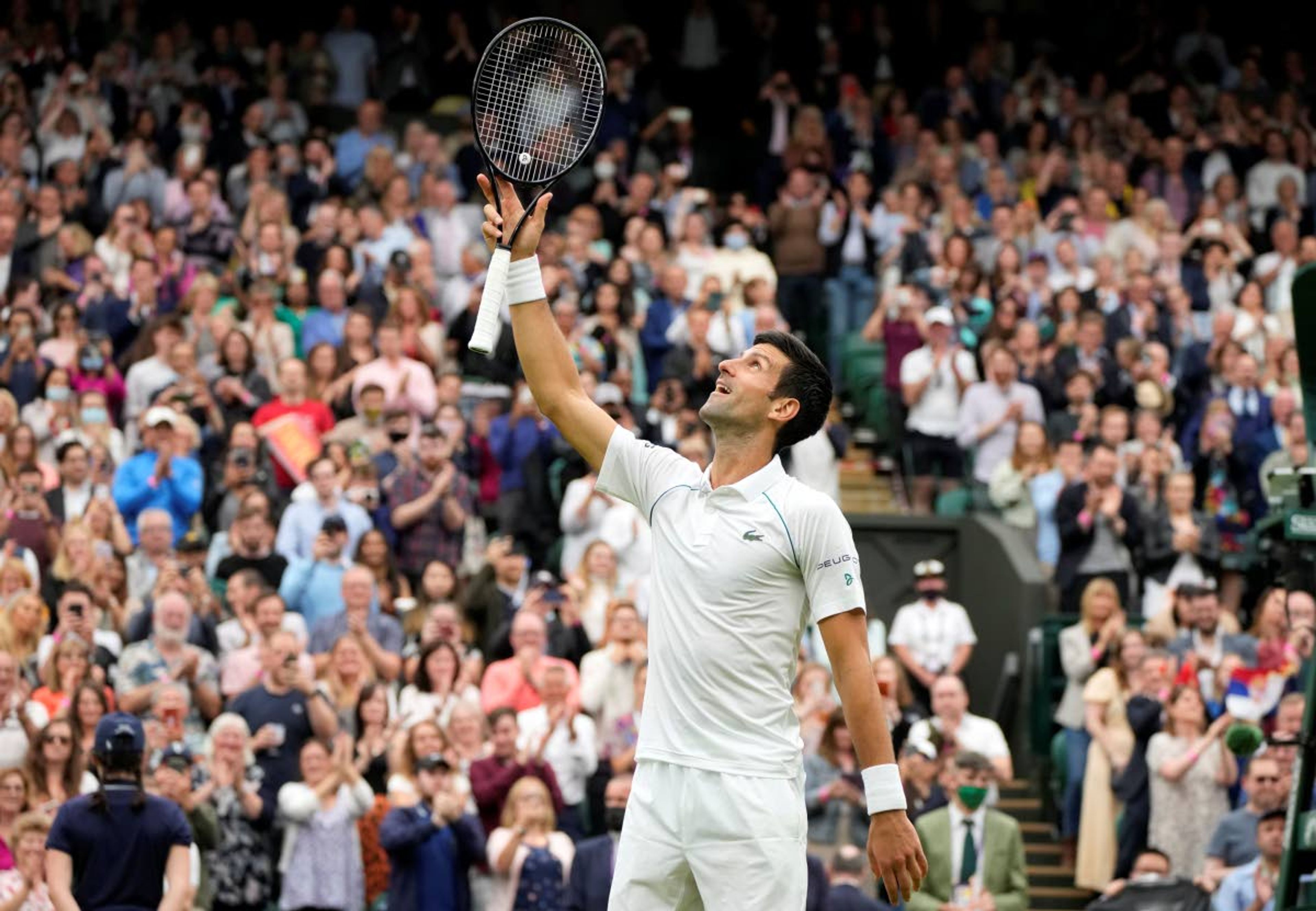 Serbia's Novak Djokovic celebrates winning the first round men's singles match against Britain's Jack Draper on day one of the Wimbledon Tennis Championships in London, Monday June 28, 2021. (AP Photo/Kirsty Wigglesworth)