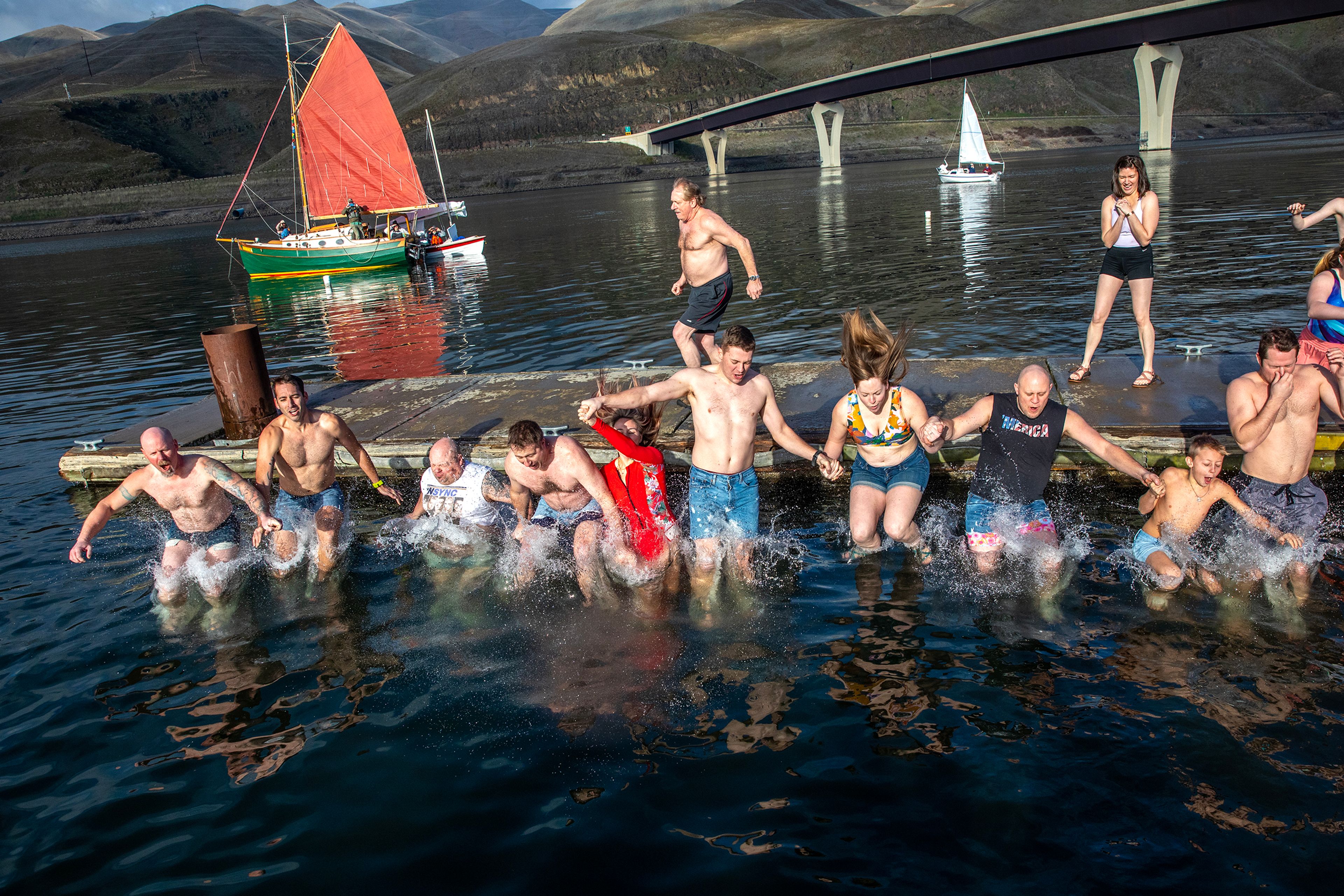 A group holds hands as they leap at the same time into the Snake River for the Polar Plunge Monday in Clarkston.