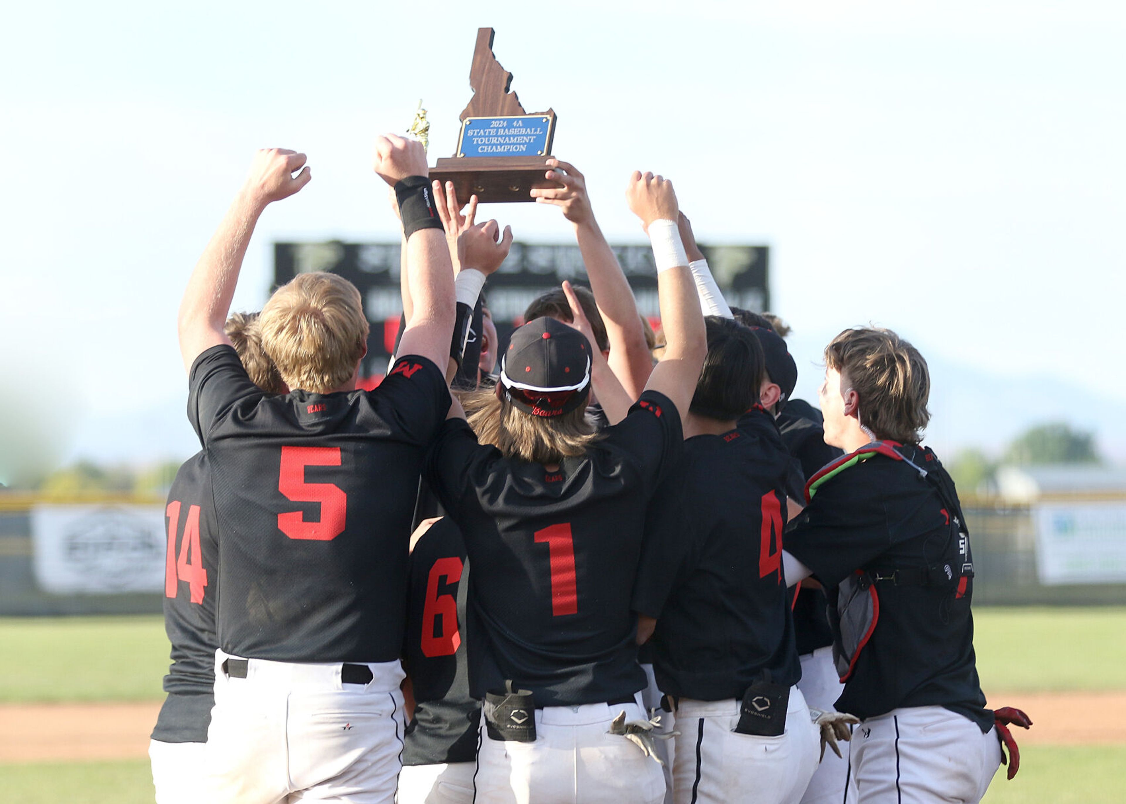 Moscow holds up the Idaho Class 4A state championship trophy after a 7-6 win against Bishop Kelly on Saturday at Vallivue High School in Caldwell, Idaho.