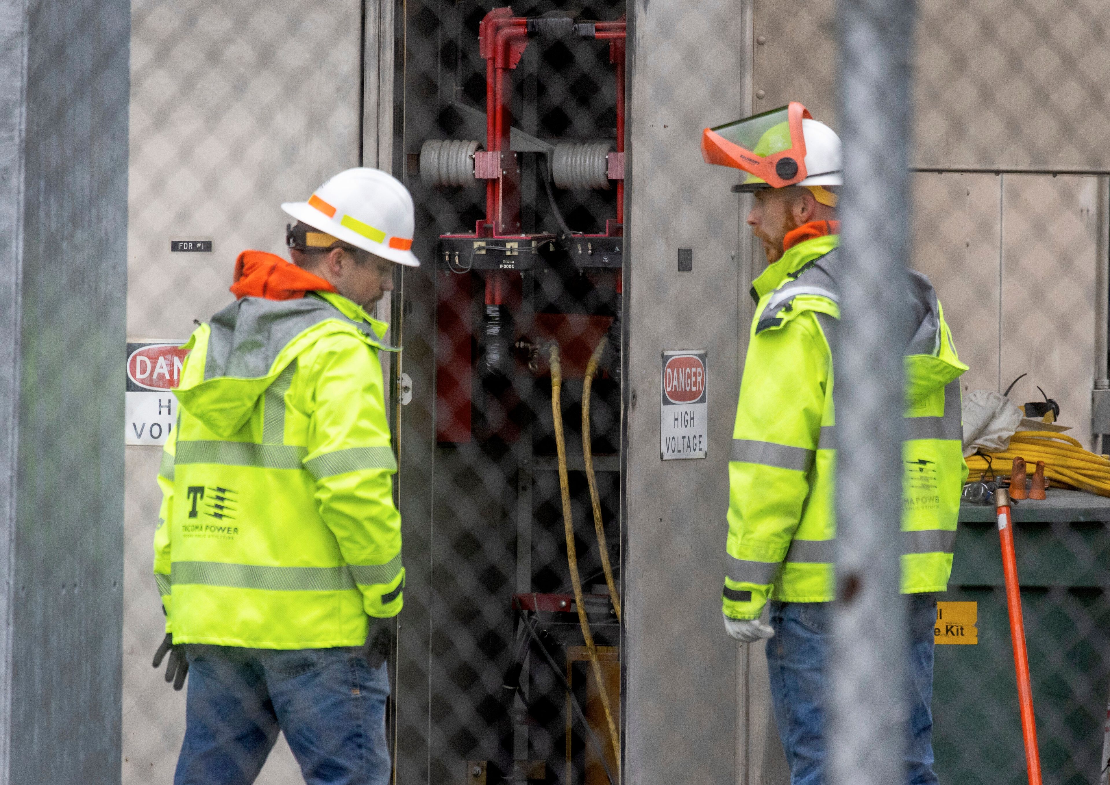 A Tacoma Power crew works at an electrical substation damaged by vandals early on Christmas morning, Sunday, Dec. 25, 2022 in Graham, Wa. (Ken Lambert/The Seattle Times via AP)