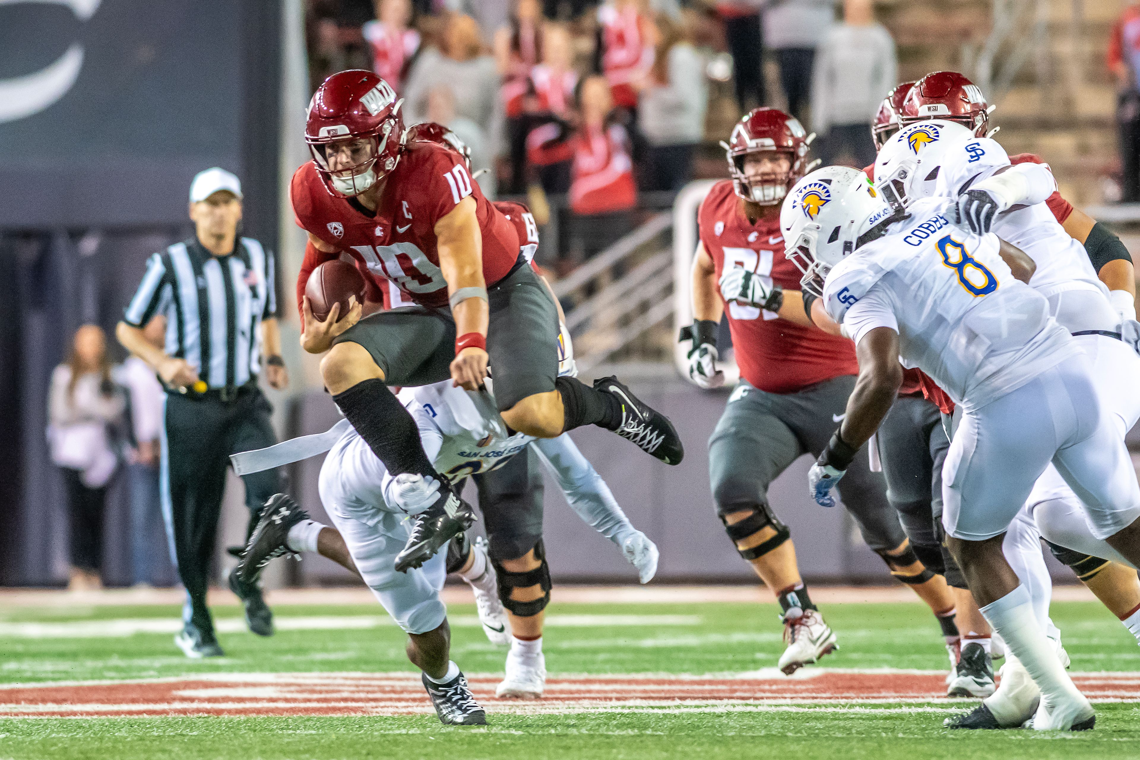 Washington State quarterback John Mateer leaps into the air as he attempts to avoid a San Jose State player during a quarter of a game Friday at Gesa Field in Pullman.,