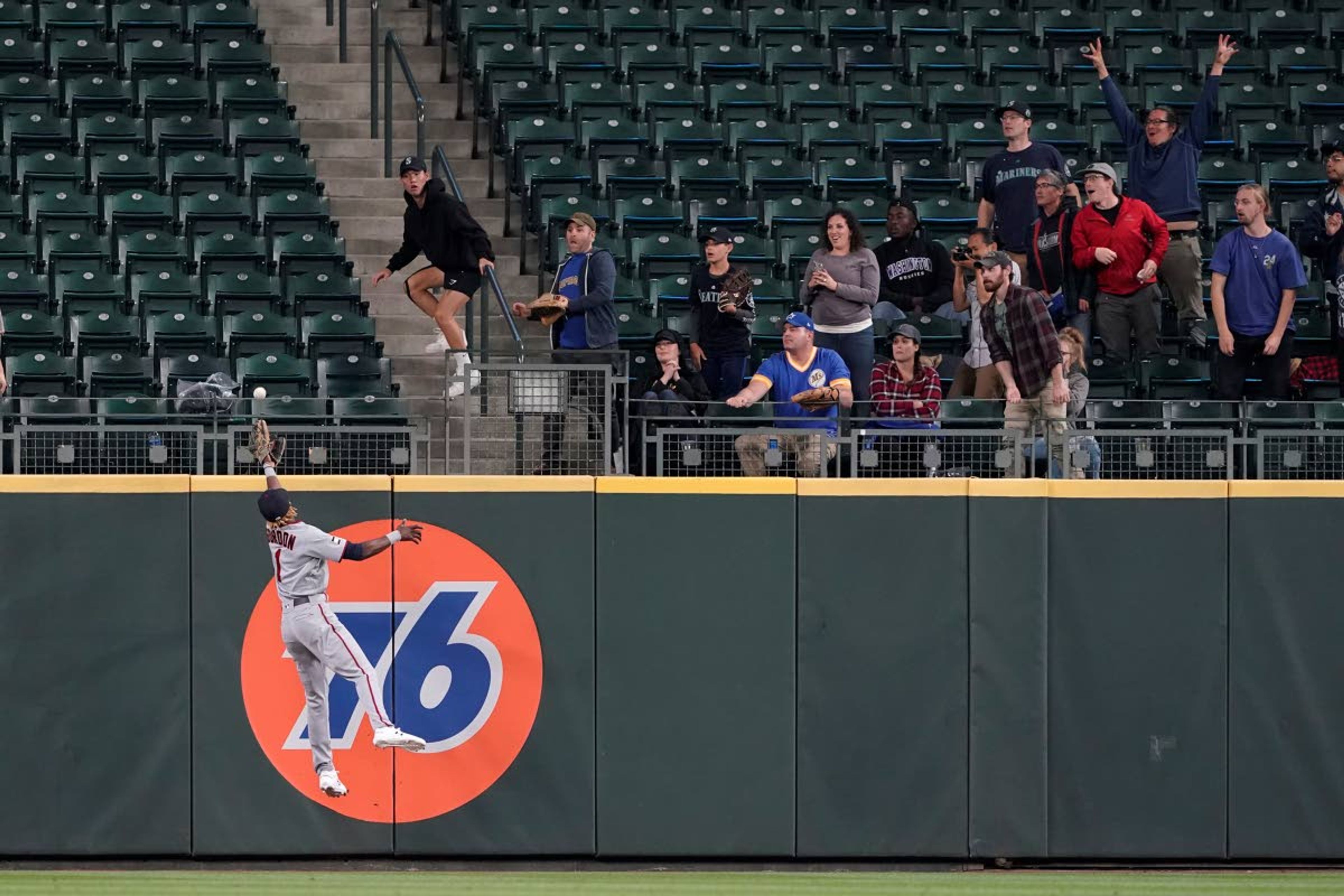 Seattle Mariners fans react as Minnesota Twins center fielder Nick Gordon leaps but can't catch a go-head solo home run hit by Seattle Mariners' Jake Bauers during the eighth inning of a baseball game, Monday, June 14, 2021, in Seattle. (AP Photo/Ted S. Warren)