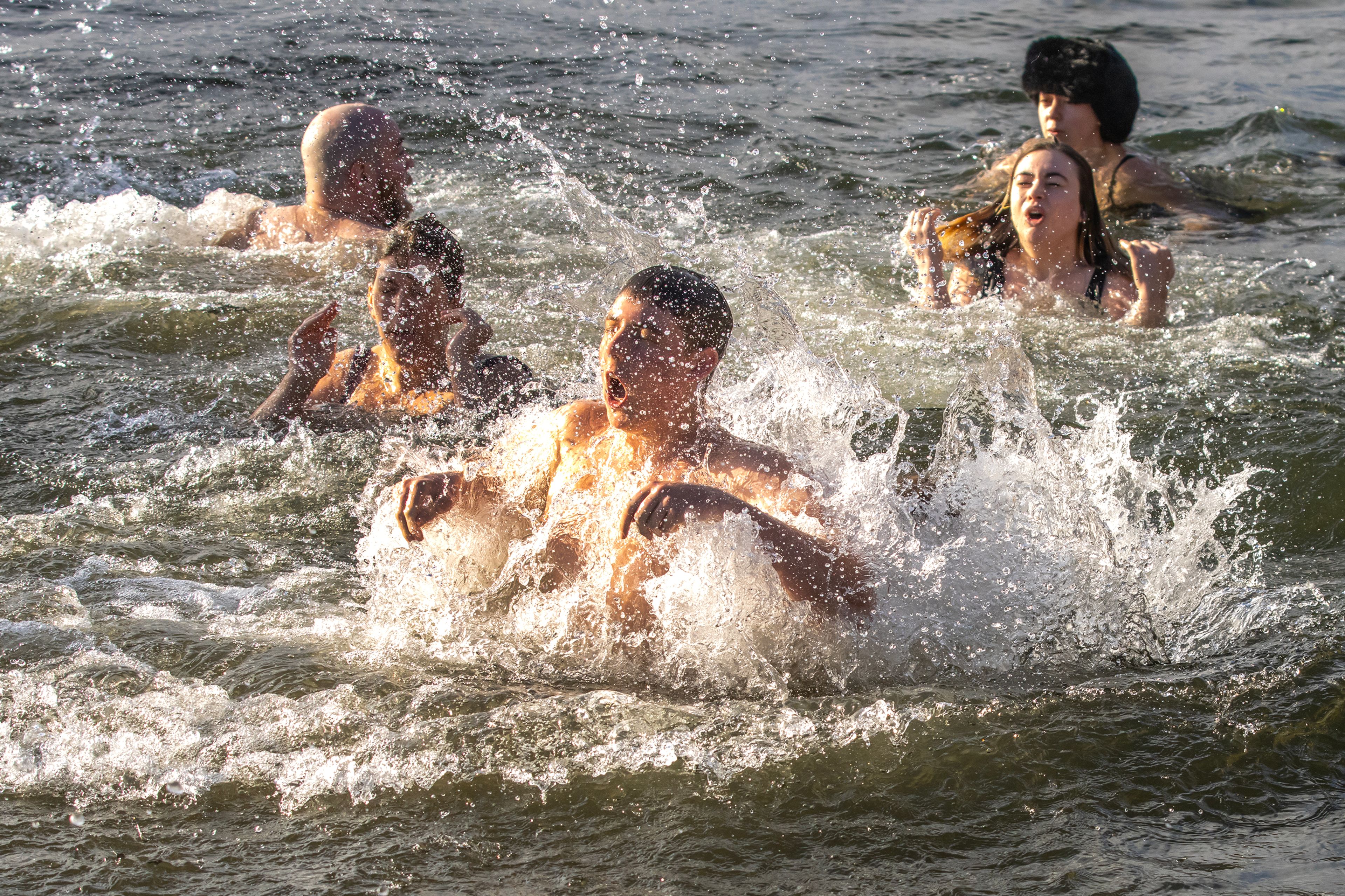 People come up for breath after jumping into the Sneak River for the Polar Plunge Monday in Clarkston.