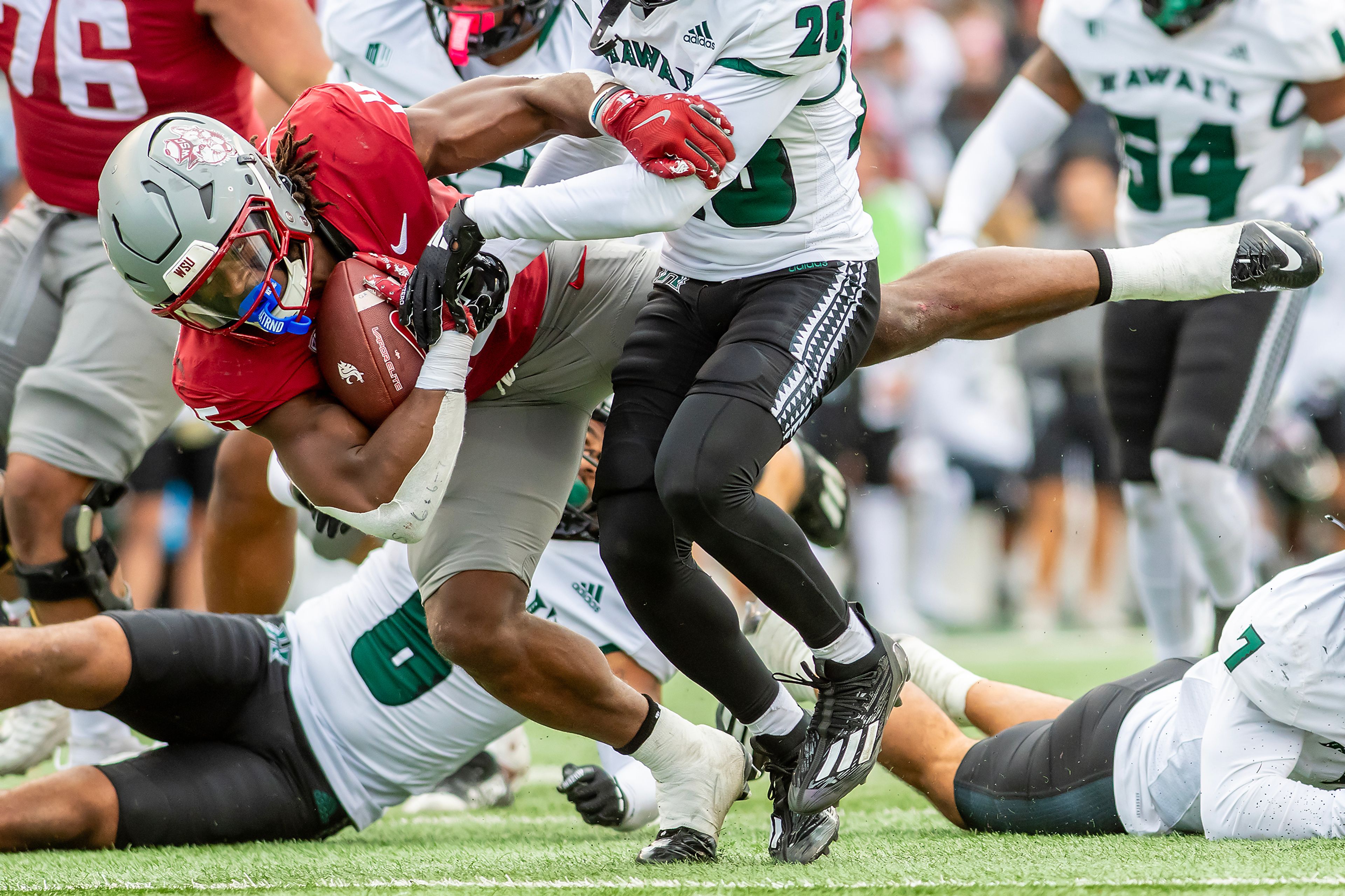 Washington State running back Djouvensky Schlenbaker is tackled by Hawaii defensive back Deliyon Freeman in a college football game on Saturday at Gesa Field in Pullman. WSU defeated Hawaii 42-10.,