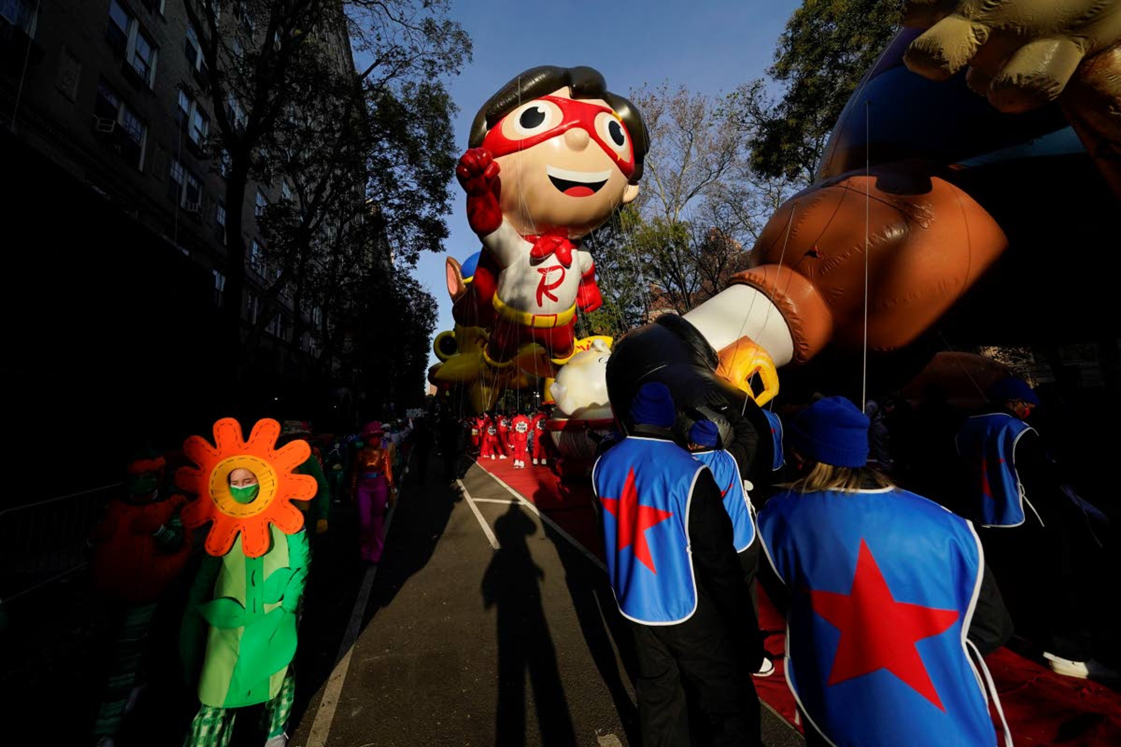 Handlers hold tethers as balloons are prepared to go down Central Park West before the start of the Macy's Thanksgiving Day Parade in New York, Thursday, Nov. 25, 2021. The parade is returning in full, after being crimped by the coronavirus pandemic last year. (AP Photo/Seth Wenig)