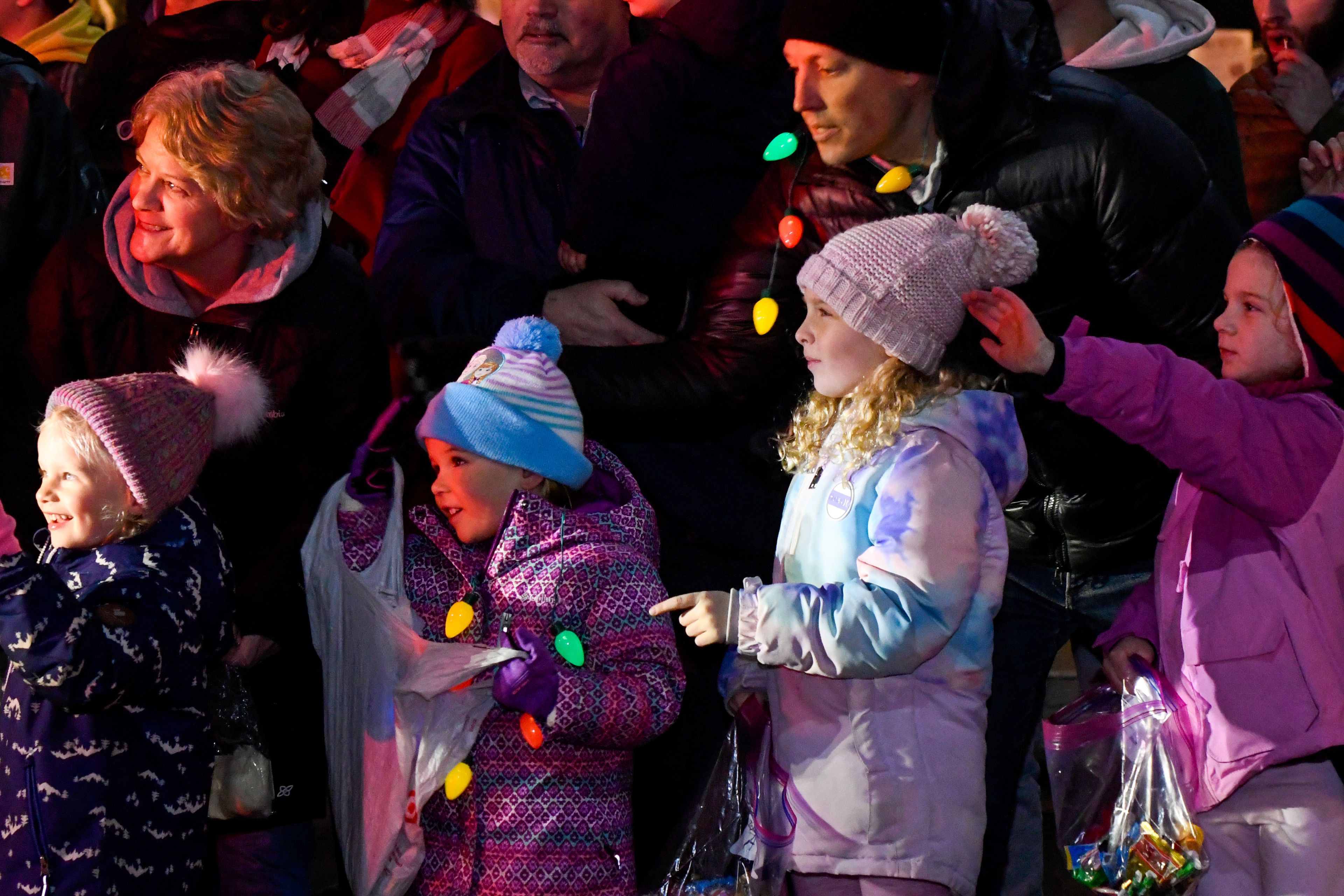 Those watching the Light Up the Season parade react to seeing Santa in the front seat of a Moscow Fire Department truck on Thursday.