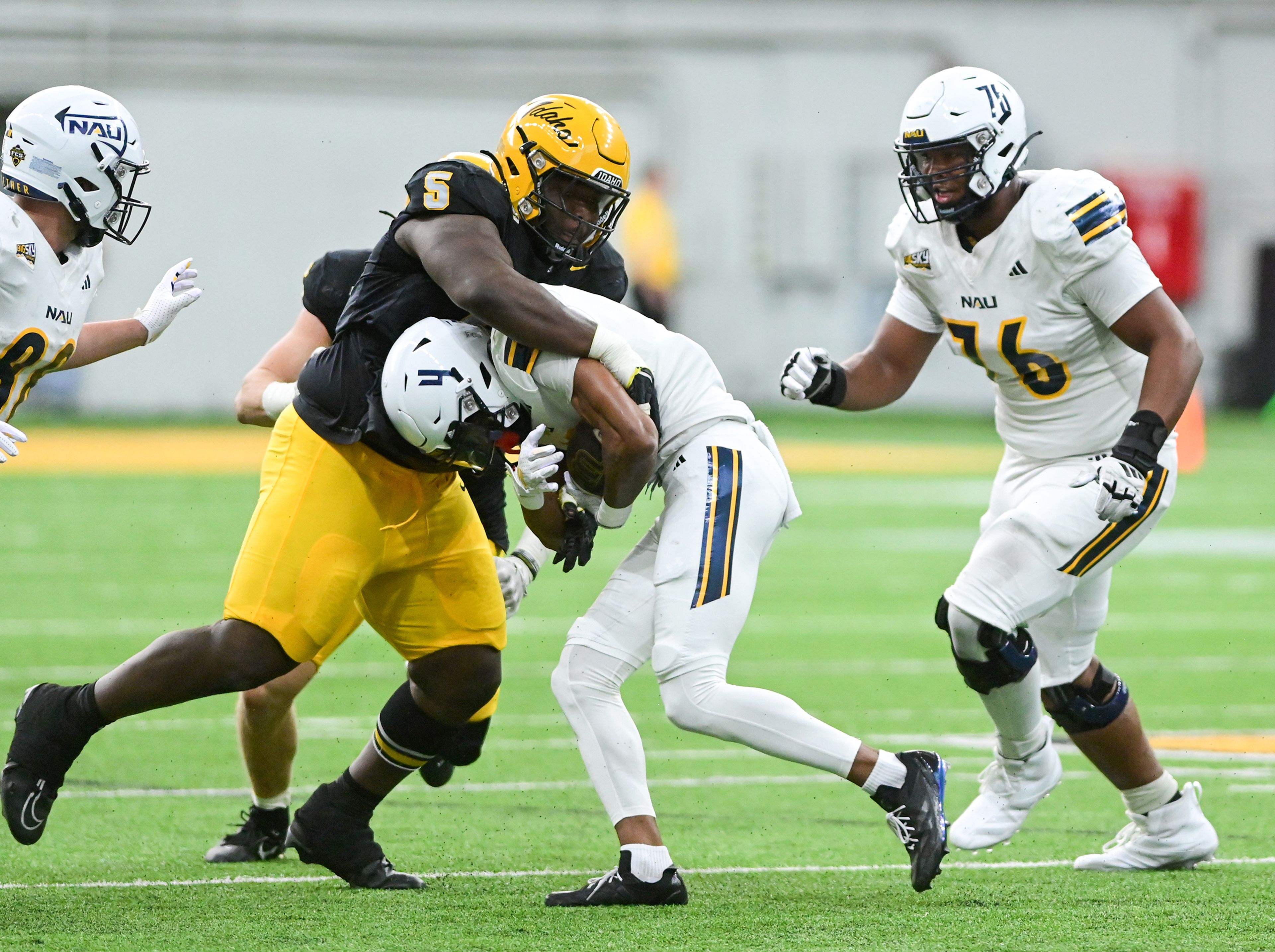 Idaho defensive lineman Jahkari Larmond tackles Northern Arizona wide receiver BJ Fleming Saturday at the P1FCU Kibbie Dome in Moscow.,