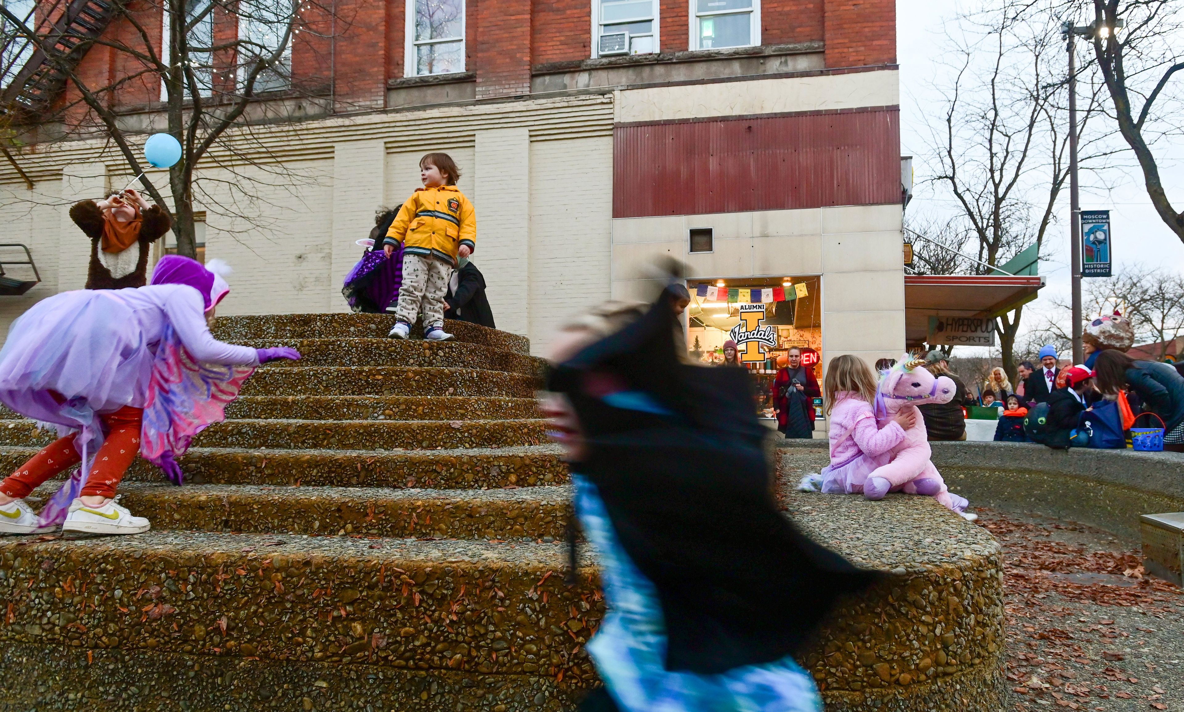 Kids climb and run around the water feature in Friendship Square in costume for Moscow’s Downtown Trick-or-Treat on Tuesday.