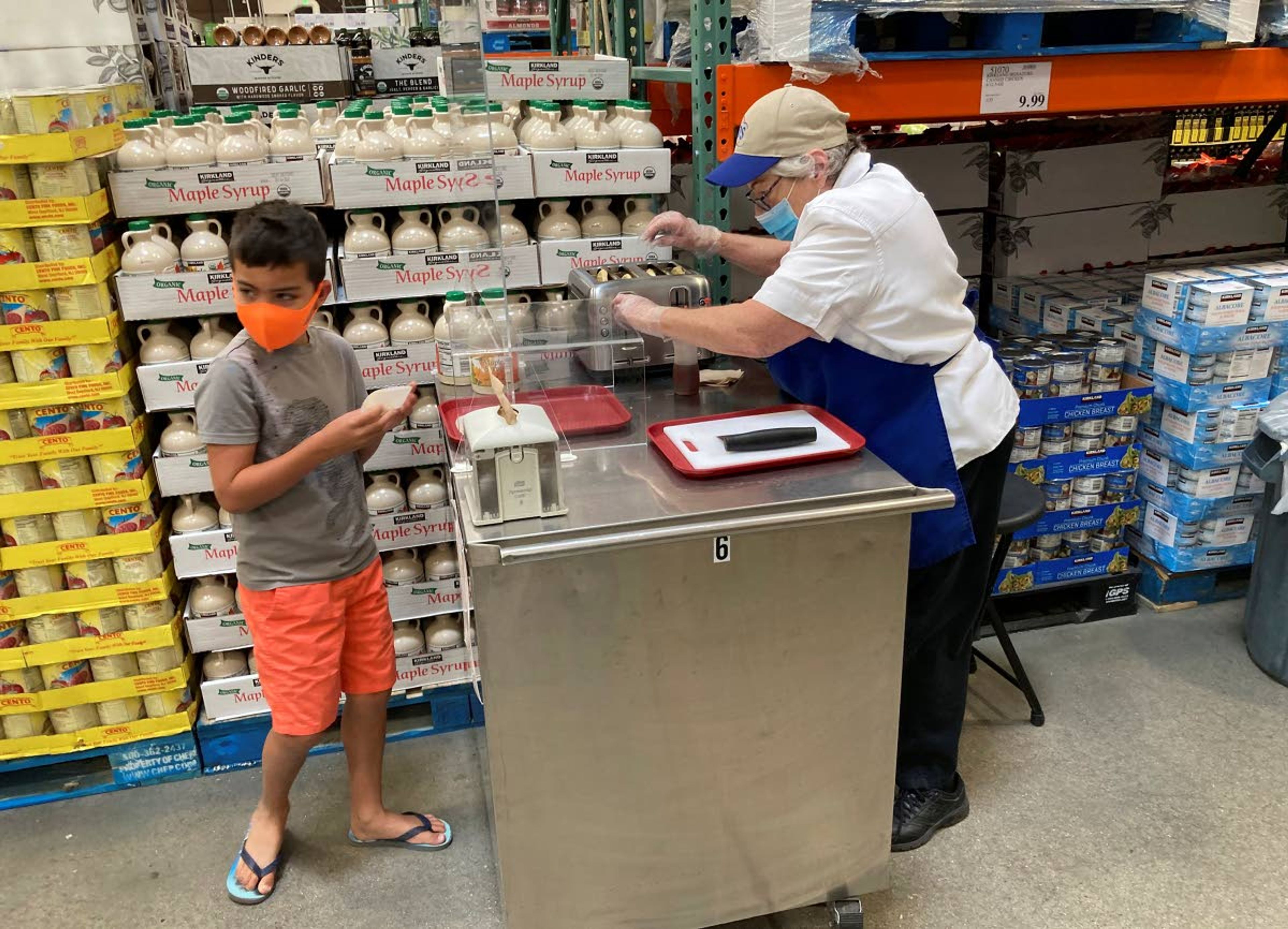 A worker offers a sample of a waffle flavored with a featured maple syrup at a Costco warehouse on Thursday, June 17, 2021, in Lone Tree, Colo. With vaccinations rolling out and the threat of COVID-19 easing in the U.S., stores are feeling confident enough to revive the longstanding tradition of offering free samples. For customers, sampling makes it fun to shop and discover new items, not to mention getting all the freebies. (AP Photo/David Zalubowski)