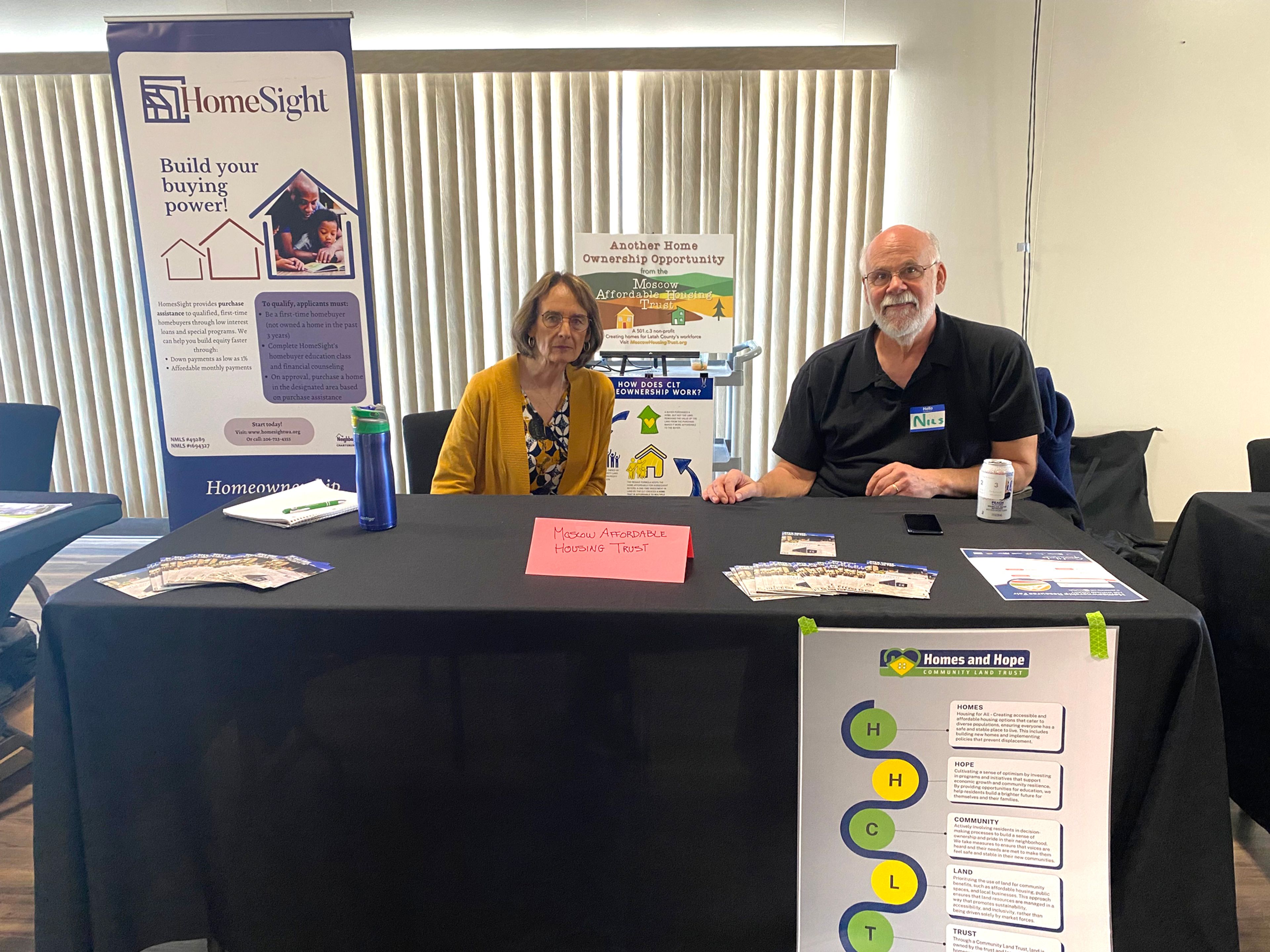 Nils Peterson, right, executive director of the Moscow Affordable Housing Trust, and Janice Smith-Hill, board member, sit at their booth during the Homeownership Resource Fair on Saturday at the Gladish View Room in Pullman.