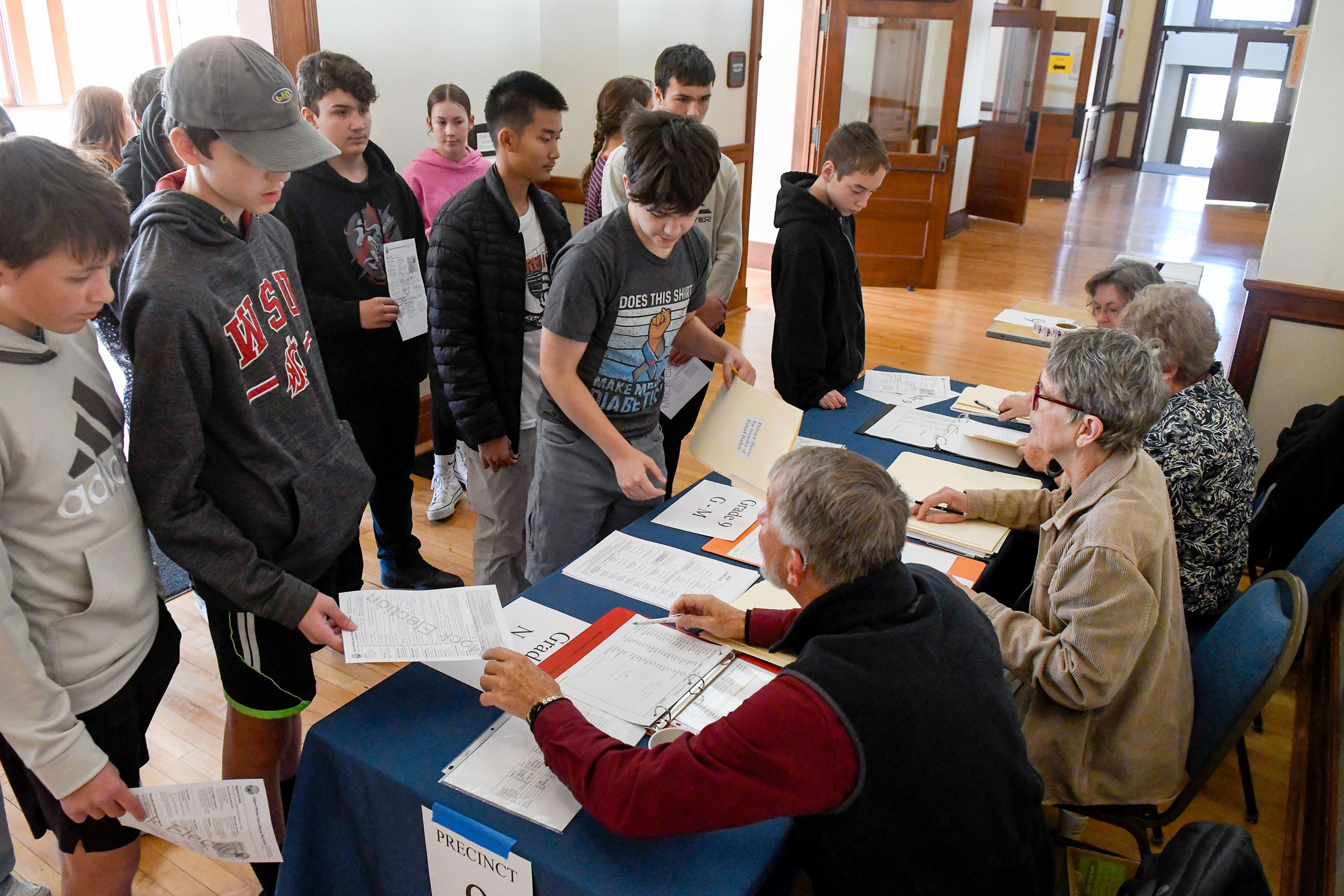 Volunteers with the League of Women Voters of Moscow hand out ballots to Moscow High School students as part of a mock election Wednesday at the 1912 Center in Moscow.