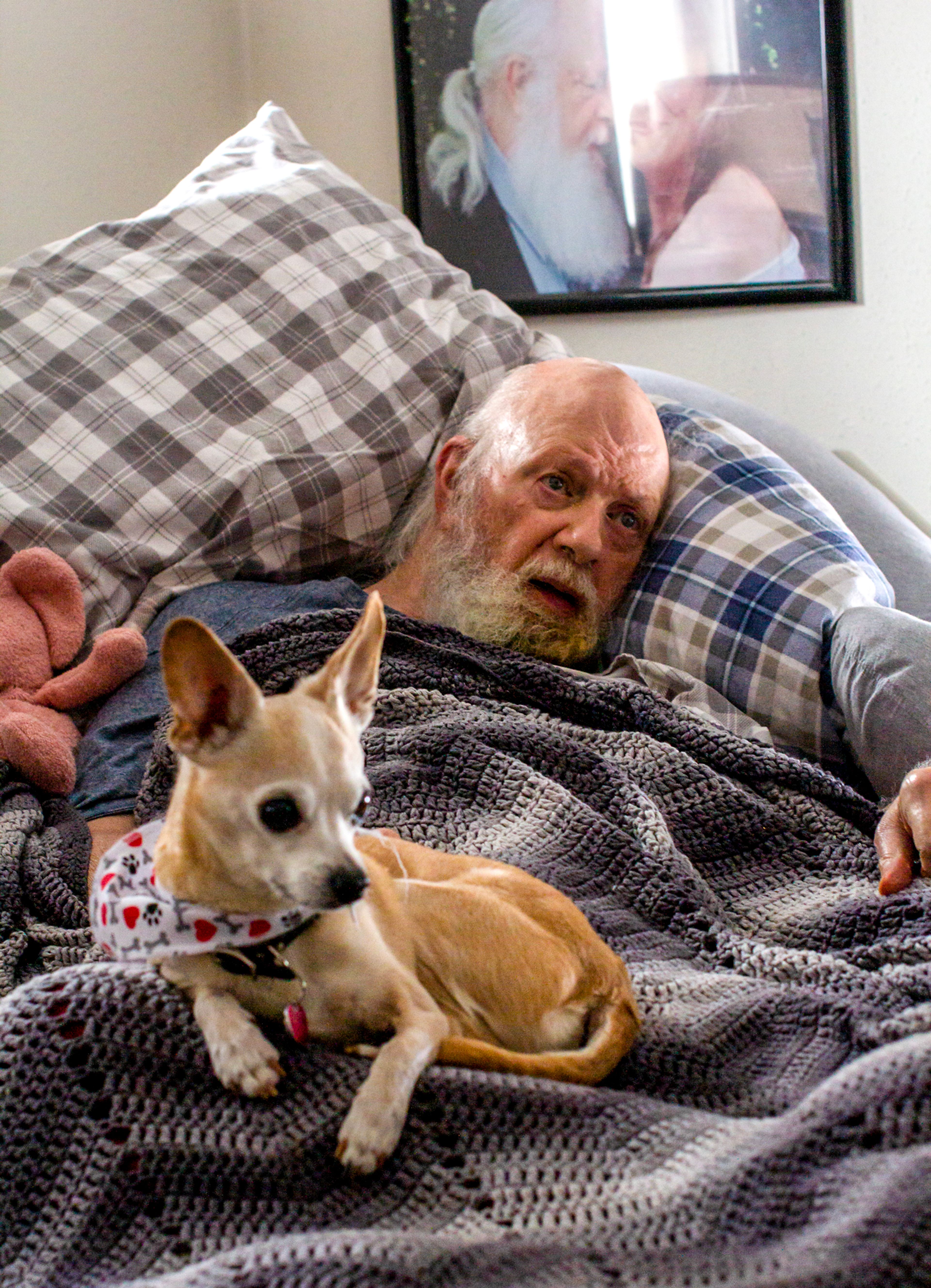 Geoff Beckett, a Kaiser Permanente customer, rests in bed with his dog, Dude, on Monday, March 6 in his Moscow home. Beckett’s wife and caregiver, Deborah Beckett, is currently paying for Geoff’s prescriptions out of pocket after learning the insurance company would require refills through its own mail order pharmacy for maintenance medications.