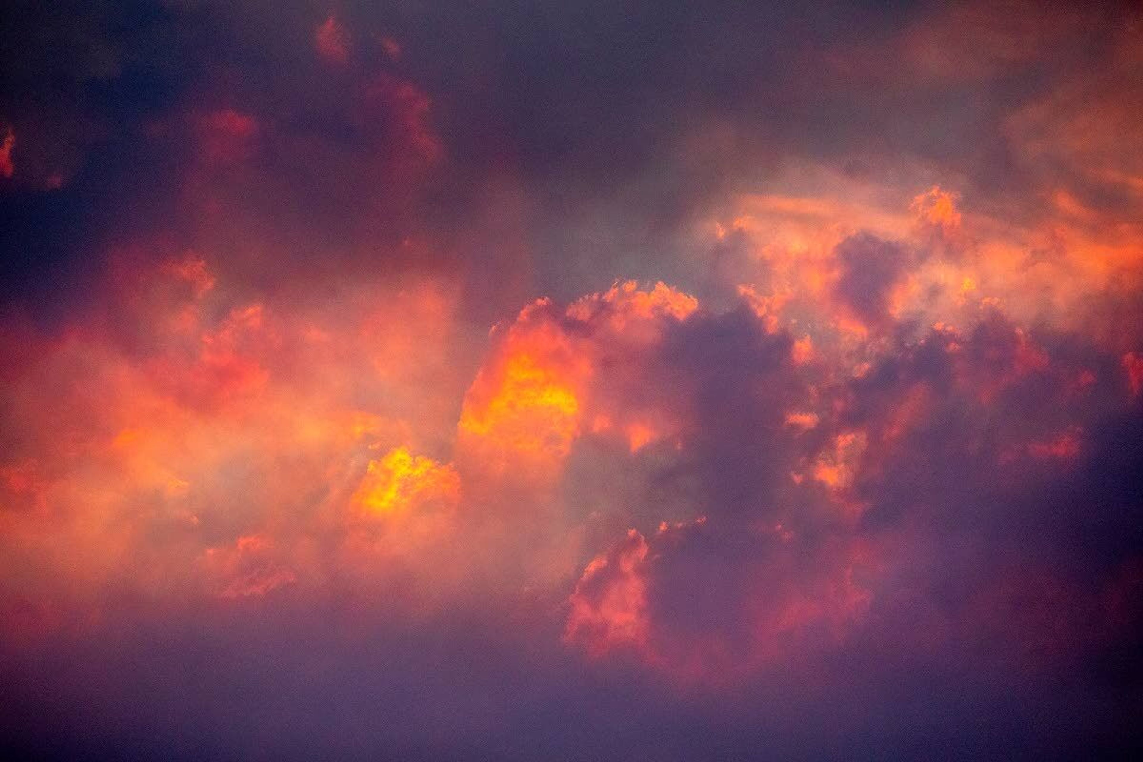 Clouds lit by the setting sun are seen through smoke drifting across the valley on Saturday.