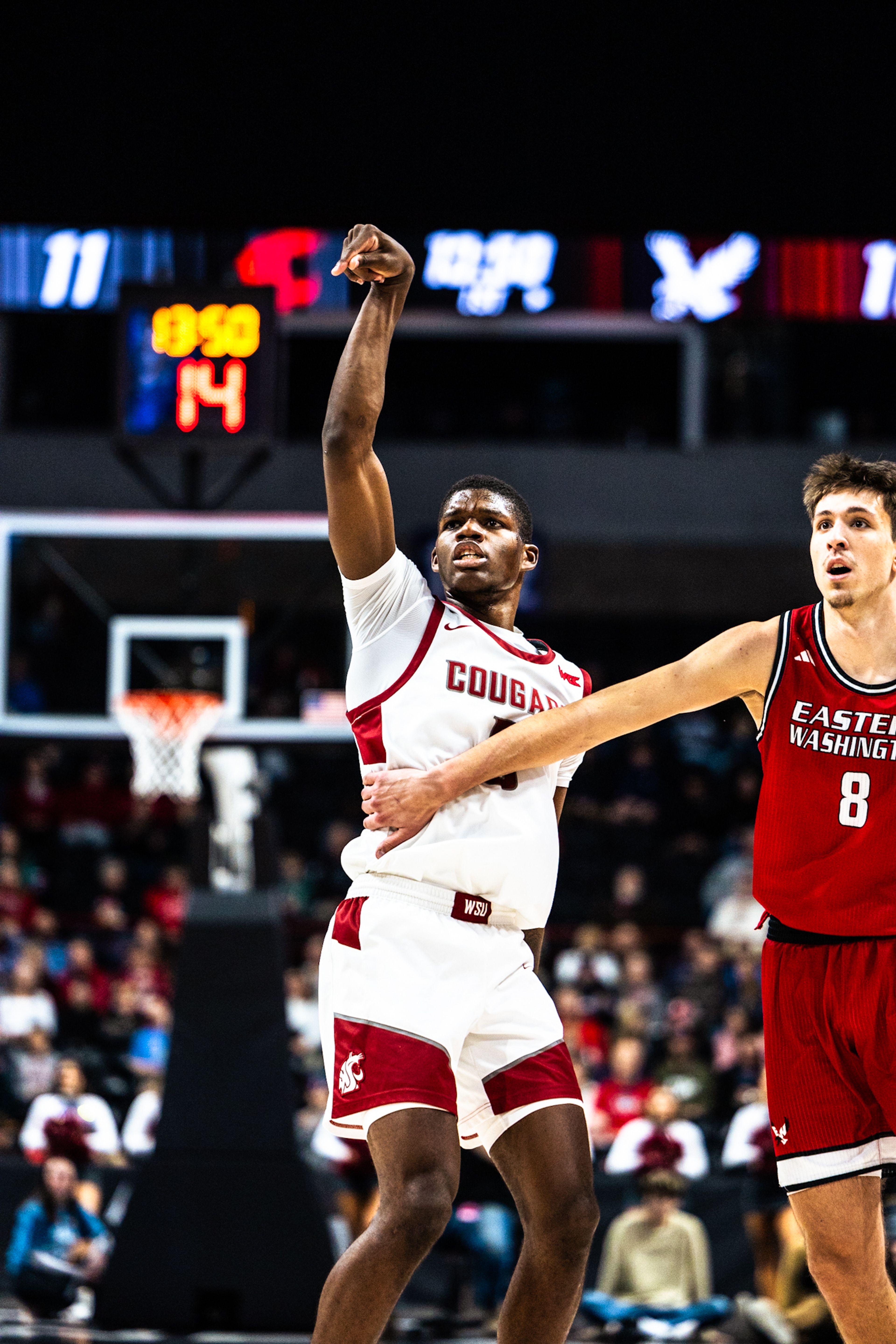 Washington State's Cedric Coward, left, follows through on a shot during a game against Eastern Washington on Thursday in Spokane.