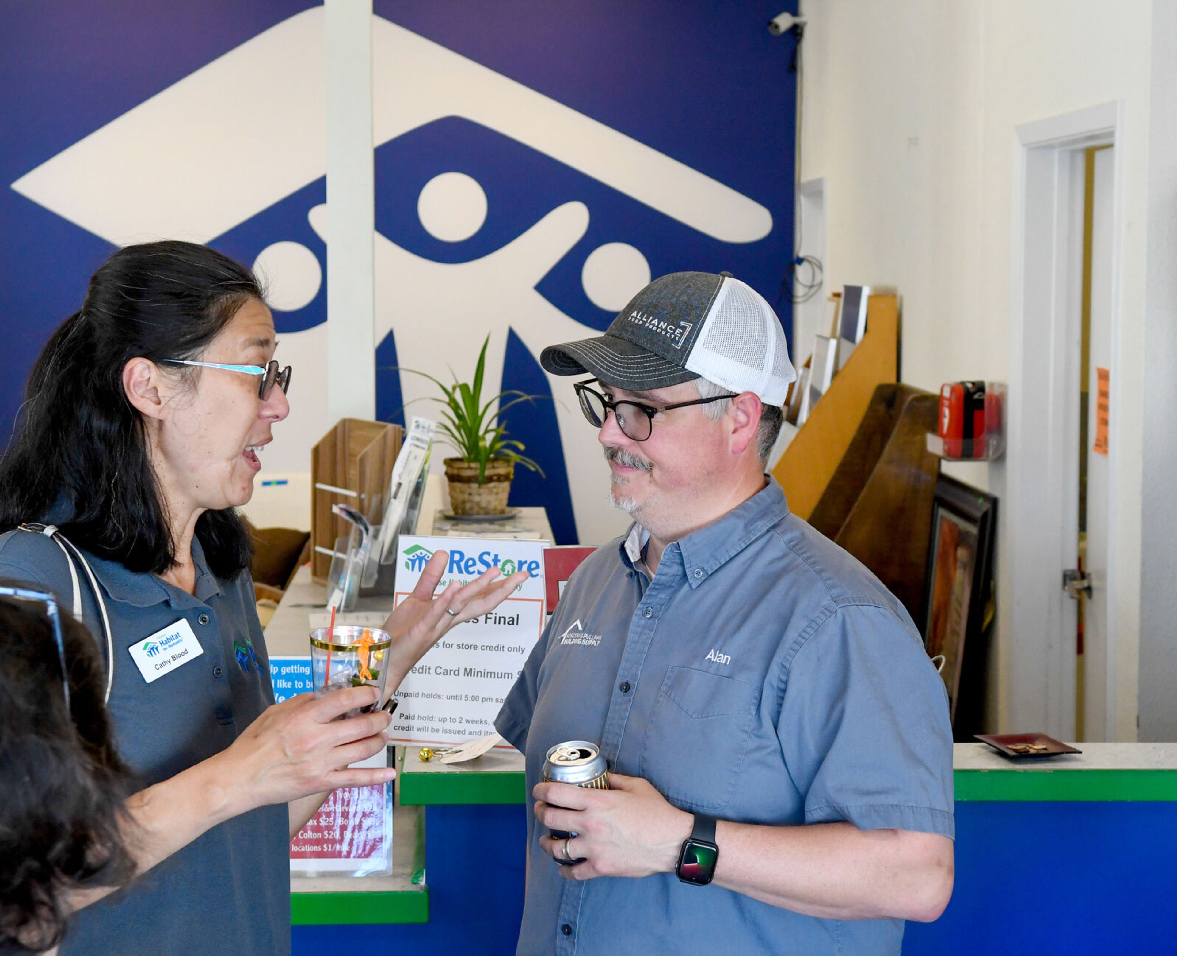 Cathy Blood, left, past president with the Palouse Habitat for Humanity board of directors, talks with Alan Espenschade, PHFH board of directors member and director of Operations at Moscow and Pullman Building Supply at the grand reopening of the ReStore in Moscow on Thursday.