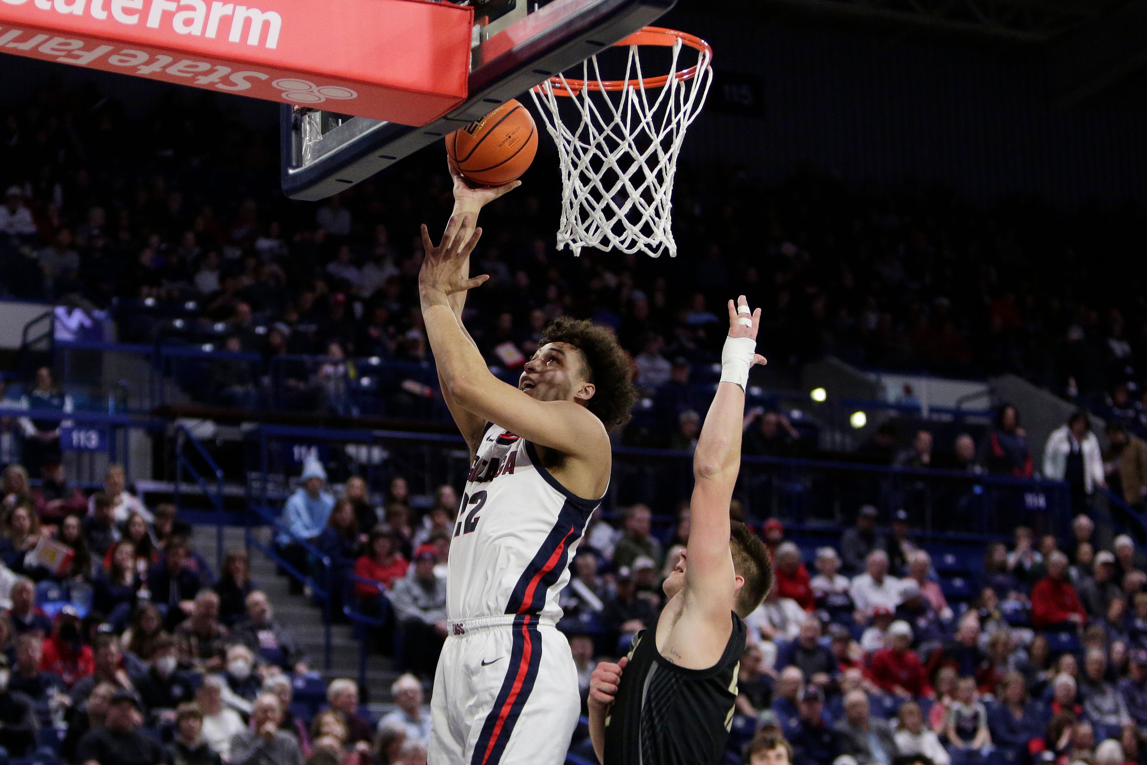 Gonzaga forward Anton Watson, left, shoots while defended by Eastern Oregon guard Justin Jeske during the second half of an NCAA college basketball game Wednesday, Dec. 28, 2022, in Spokane, Wash. Gonzaga won 120-42. (AP Photo/Young Kwak)