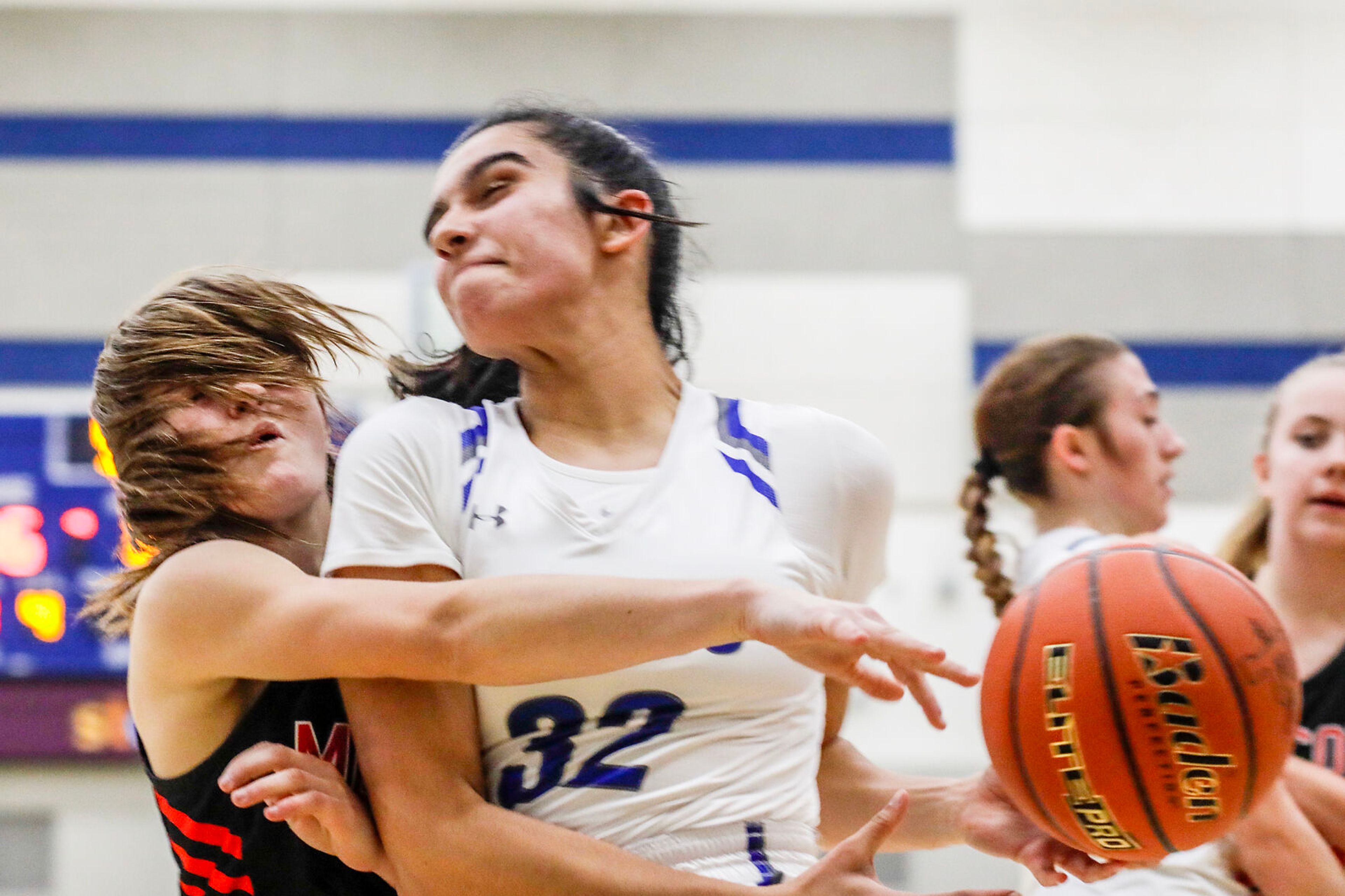 Pullman post Sehra Singh, center, collides with Moscow guard McKenna Knott as she drives toward the basket during Saturday's nonleague girls basketball game.