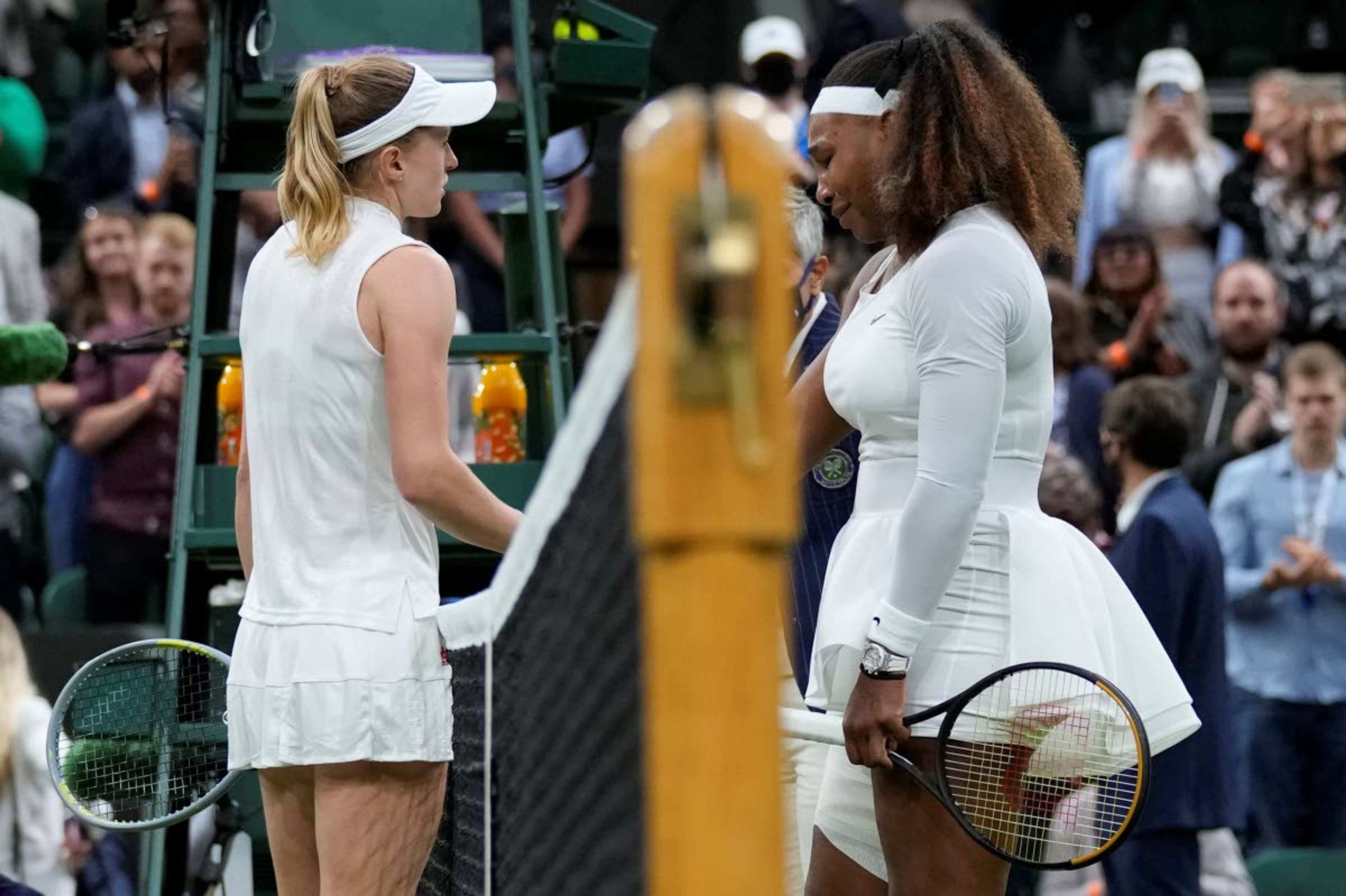 Serena Williams of the US is greeted by Aliaksandra Sasnovich of Belarus, left, at the net after retiring from the women's singles first round match against on day two of the Wimbledon Tennis Championships in London, Tuesday June 29, 2021. (AP Photo/Kirsty Wigglesworth)