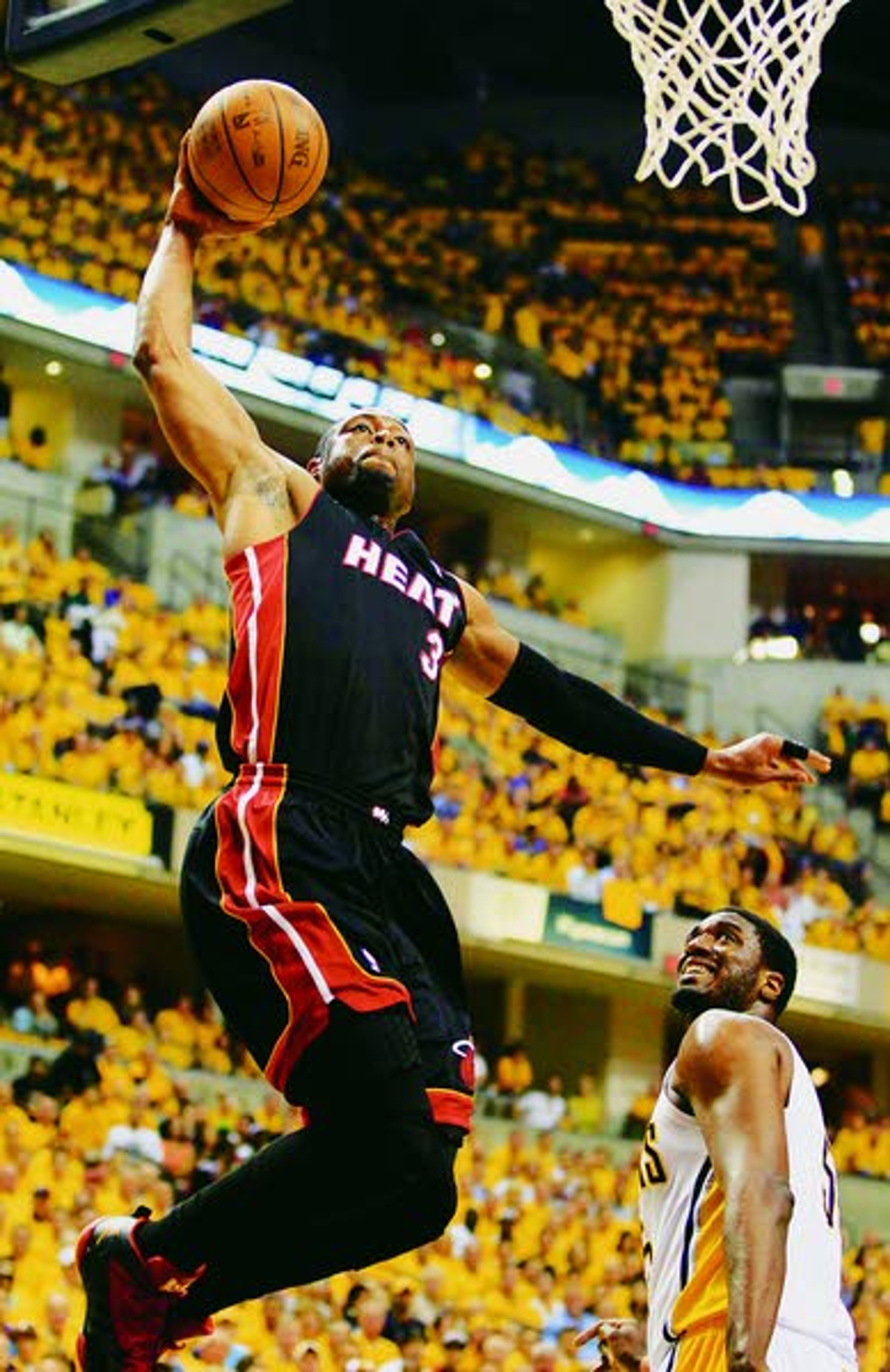 Heat’s Dwyane Wade dunks as Pacers’ Roy Hibbert watches during the first half of Game 6 of their Eastern Conference semifinal playoff series on Thursday in Indianapolis.