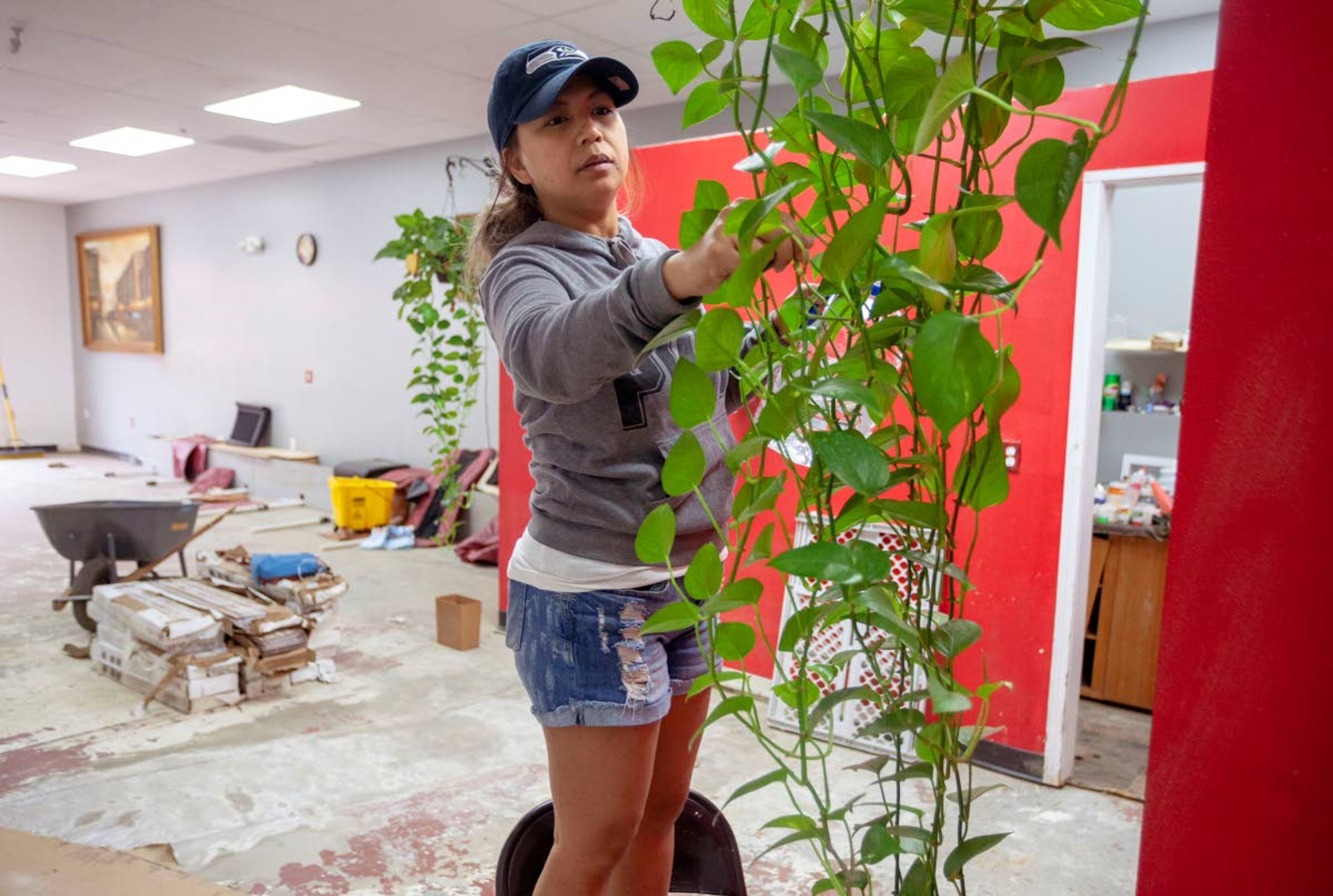 Geoff Crimmins/Daily NewsCharibelle Ladera waters a plant at Kool Nails on Wednesday in Pullman. The business, which was damaged by floodwater in April, hopes to reopen in two or three weeks.