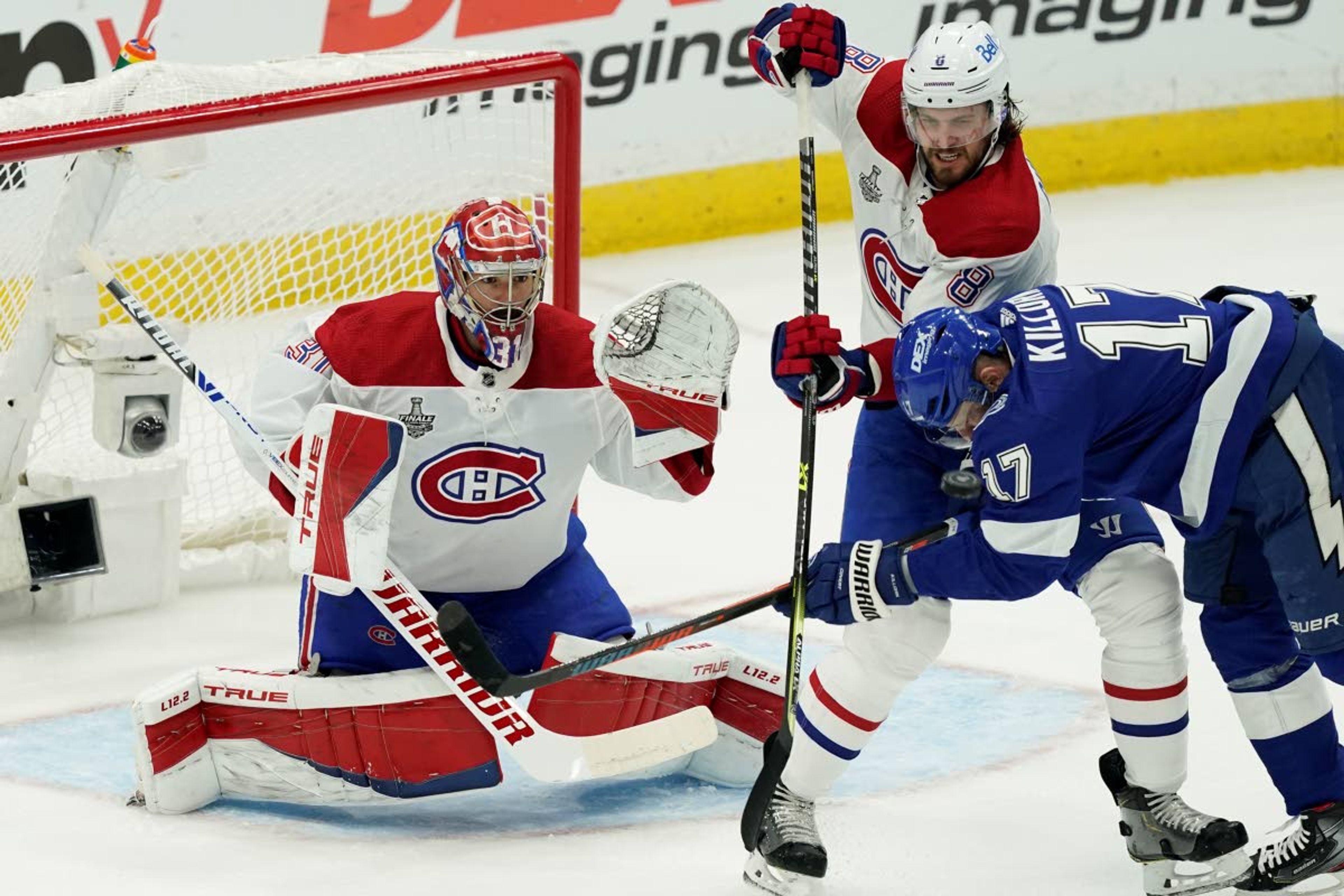 Montreal Canadiens defenseman Ben Chiarot (8) checks Tampa Bay Lightning left wing Alex Killorn (17) in front of Canadiens goaltender Carey Price (31) during the first period in Game 1 of the NHL hockey Stanley Cup finals, Monday, June 28, 2021, in Tampa, Fla. (AP Photo/Gerry Broome)