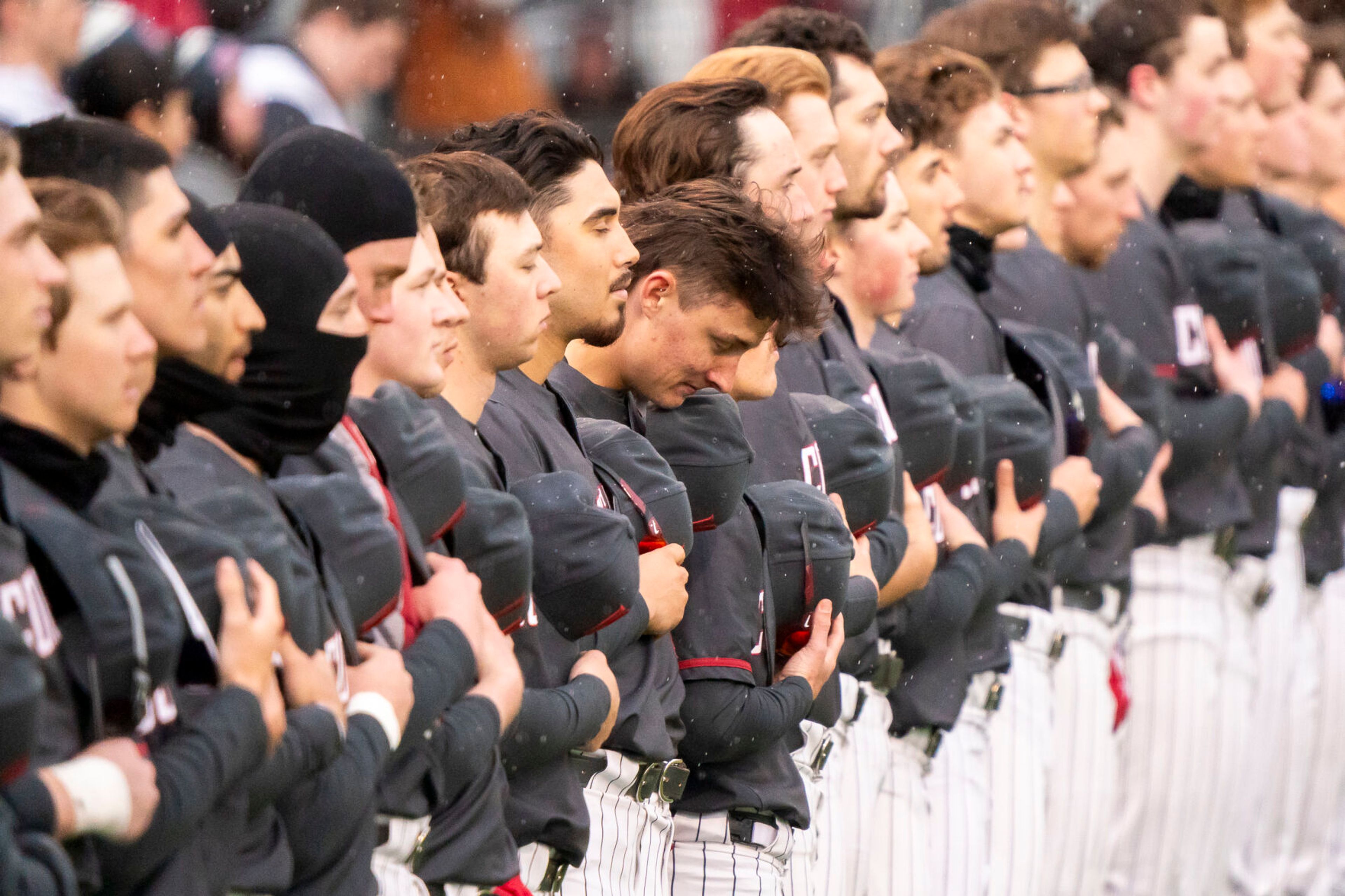 The Washington State baseball team listens to the National Anthem as rain falls before their home opener against Rhode Island on March 1 at Bailey-Brayton Field in Pullman.