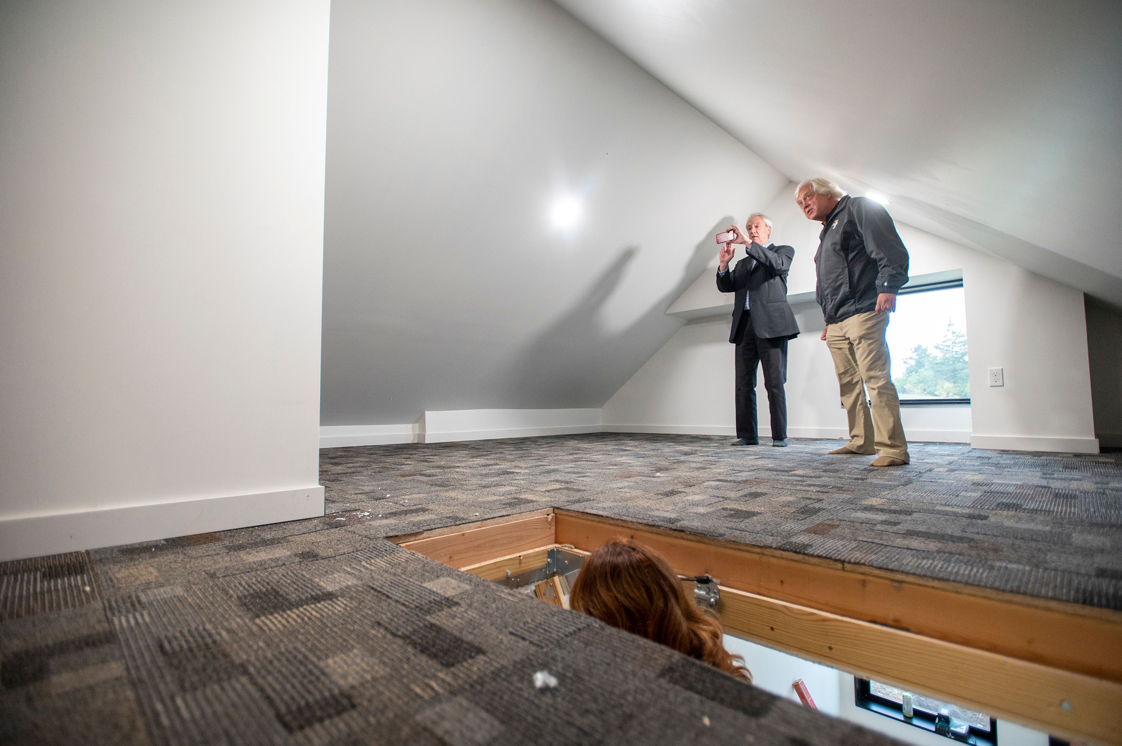 Dave Huotari, left, and Stan Palmer, both University of Idaho College of Art and Architecture advisory council members, tour the loft of a newly built home by members of Moscow Affordable Housing Trust and the University of Idaho in Moscow on Friday.