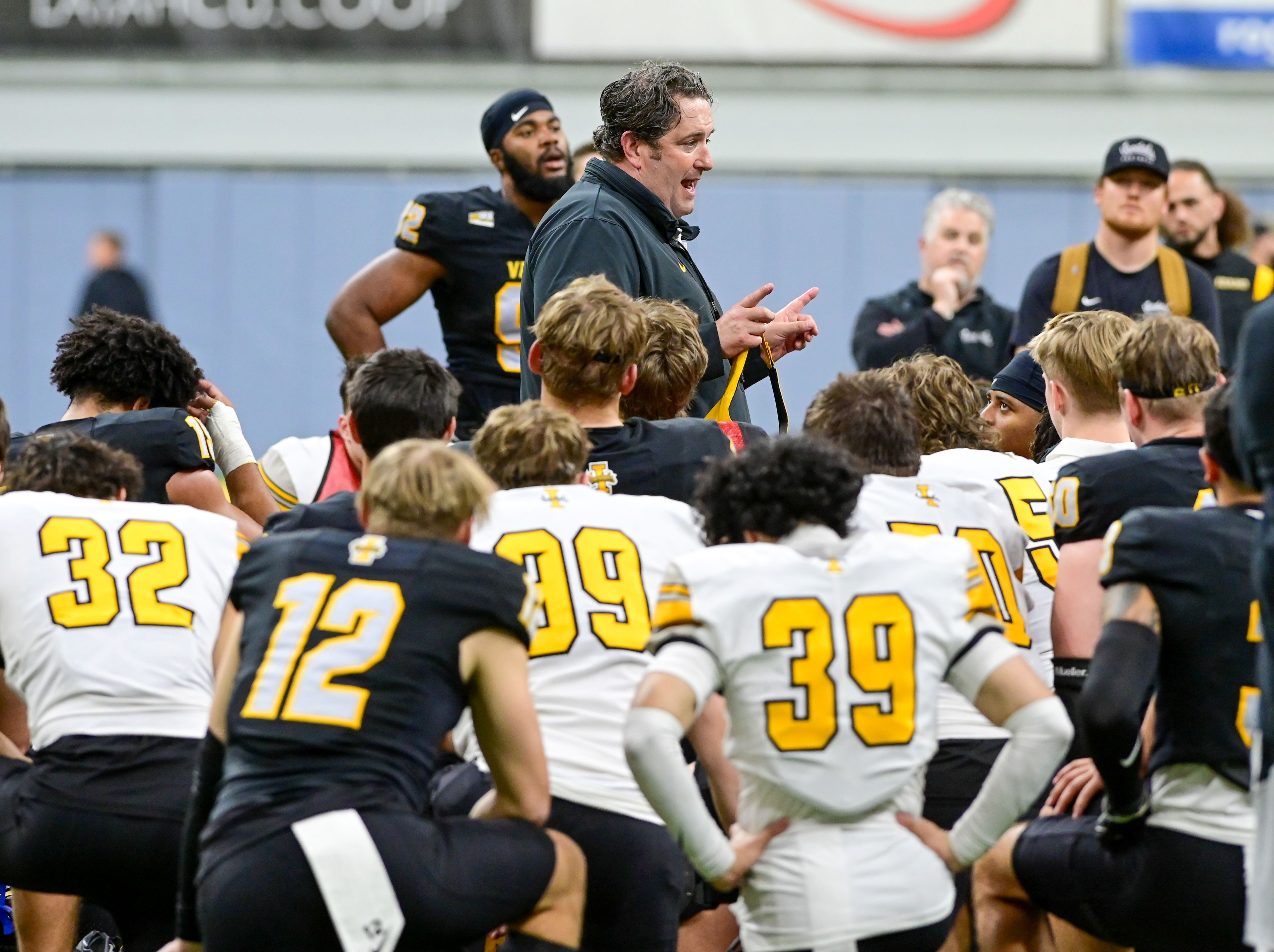 Vandals head coach Jason Eck speaks to players in a huddle after the annual spring game at the P1FCU Kibbie Dome in Moscow on Friday.