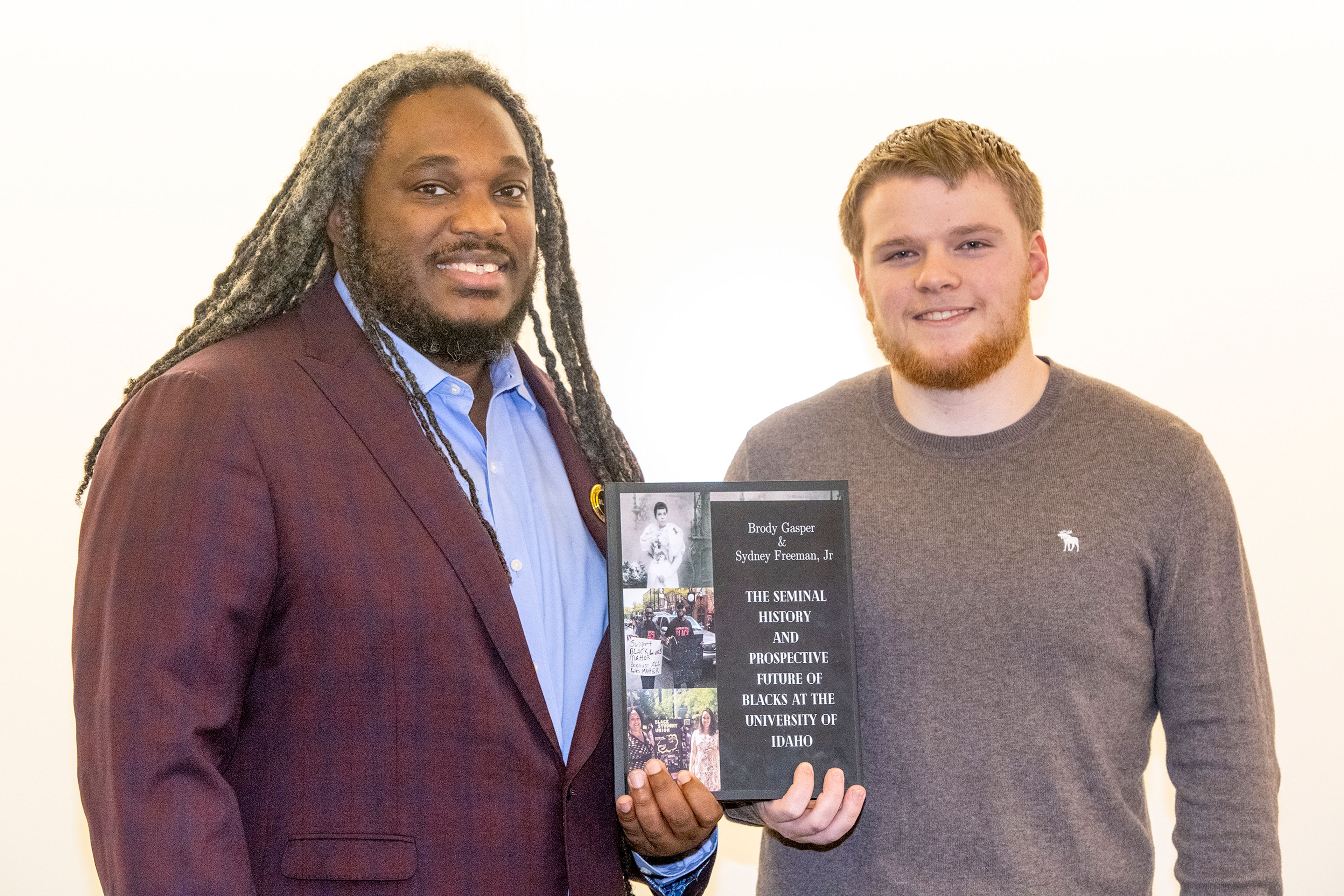 Director Sydney Freeman, Jr., and project manager Brody Gasper pose Monday with a copy of their new book, “The Seminal History and Prospective Future of Blacks at the University of Idaho,” in the Integrated Research and Innovation Center on campus in Moscow.