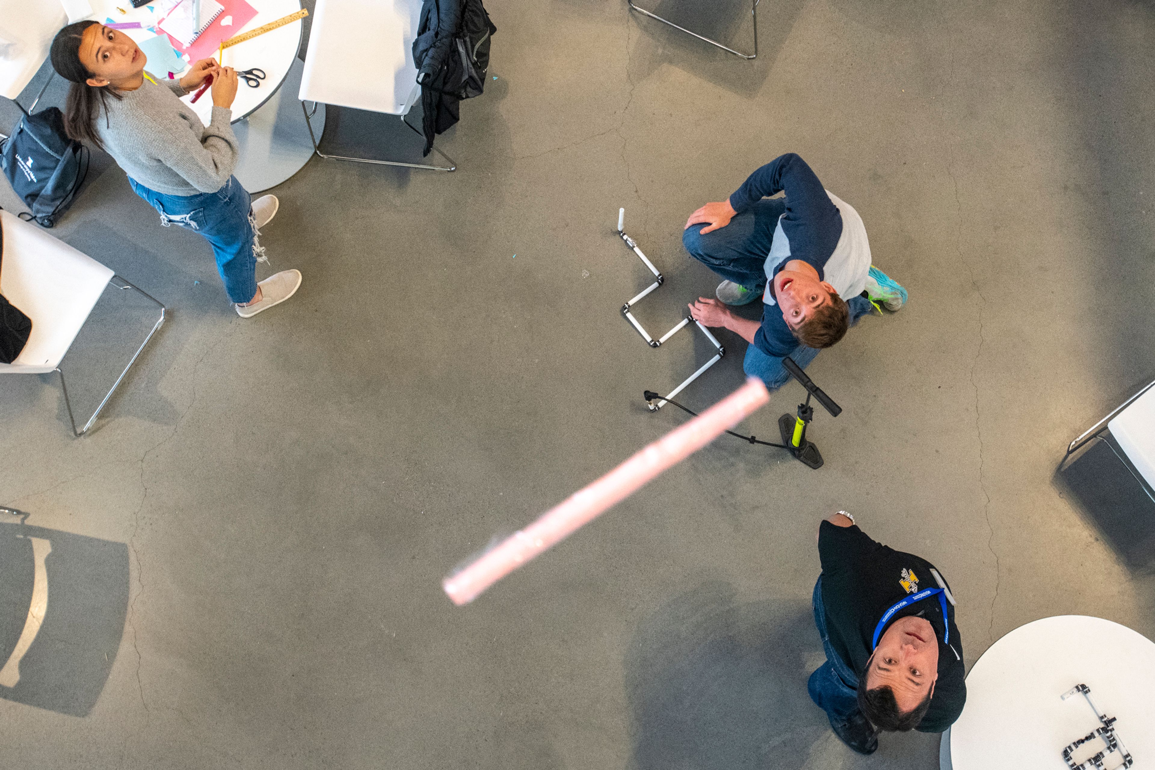 Sydney Arellano, of Lewiston, from left, Aydin Hasz, of Wallace, Idaho, and Matt Bernards, director of the NASA Idaho Space Grant Consortium, watch as the students conduct a test launch of their air-powered rockets during the Idaho Science and Aerospace Scholars capstone event Monday inside the atrium of the Integrated Research and Innovation Center on University of Idaho’s campus in Moscow.