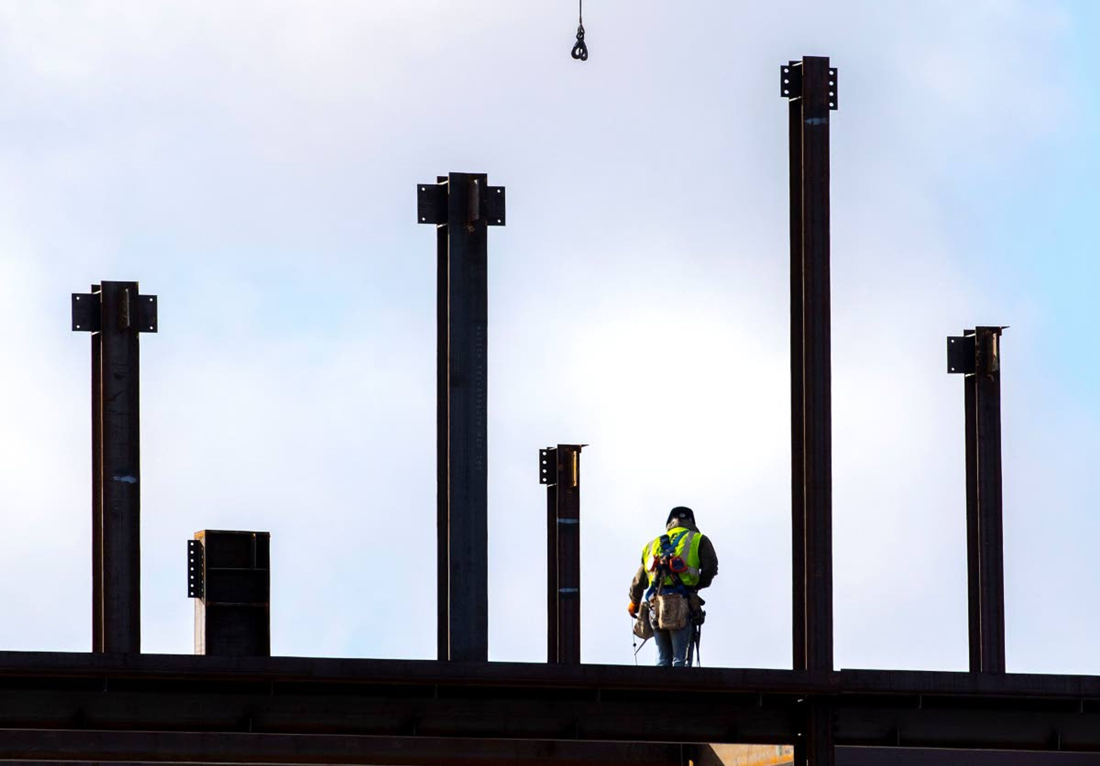 A construction worker is surrounded by steel beams while working on the new Emsi building Monday at the intersection of Jackson and C streets in Moscow.