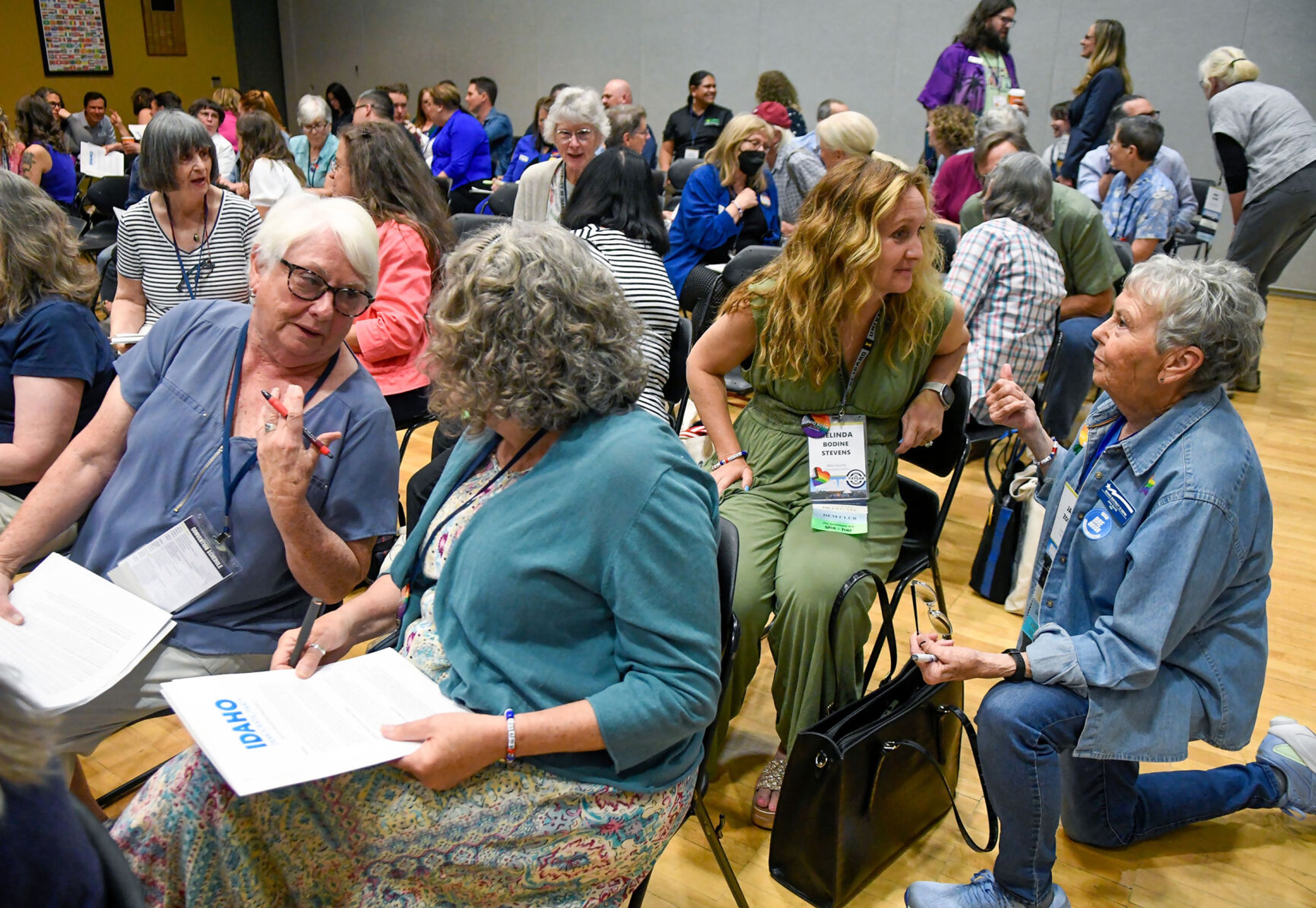 Those gathered at the Idaho Democratic Convention on Saturday, including Melinda Bodine Stevens, of Ada County, and Jane Zornik, right, chair of Idaho District 12 Dems, turn to greet one another with a prompt before the start of the Platform Hearing in Moscow.