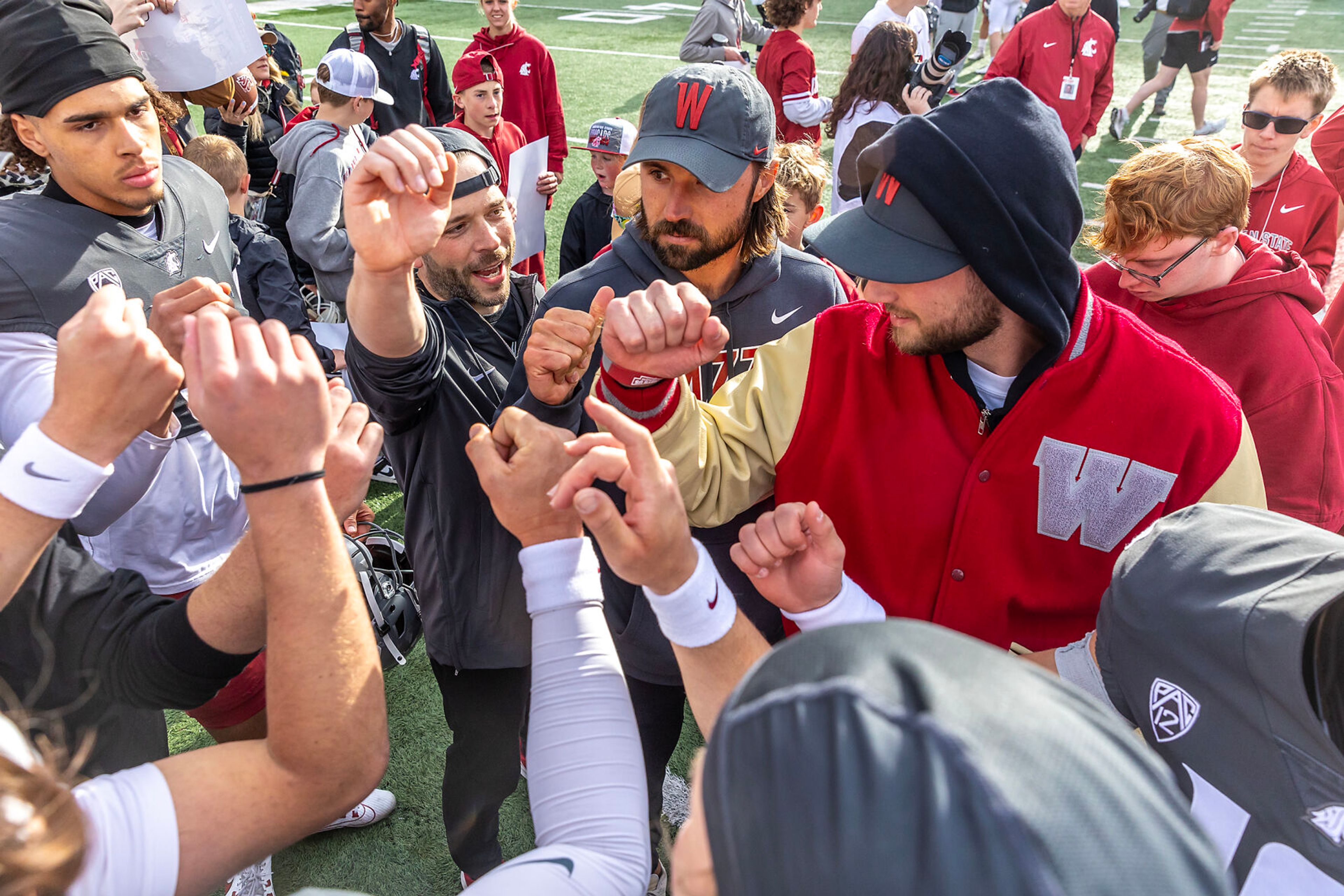 Former Cougars Gardner Minshew, center, and Anthony Gordon, right, put their fists in with current Cougars after the Crimson and Gray Game at Washington State University in Pullman.