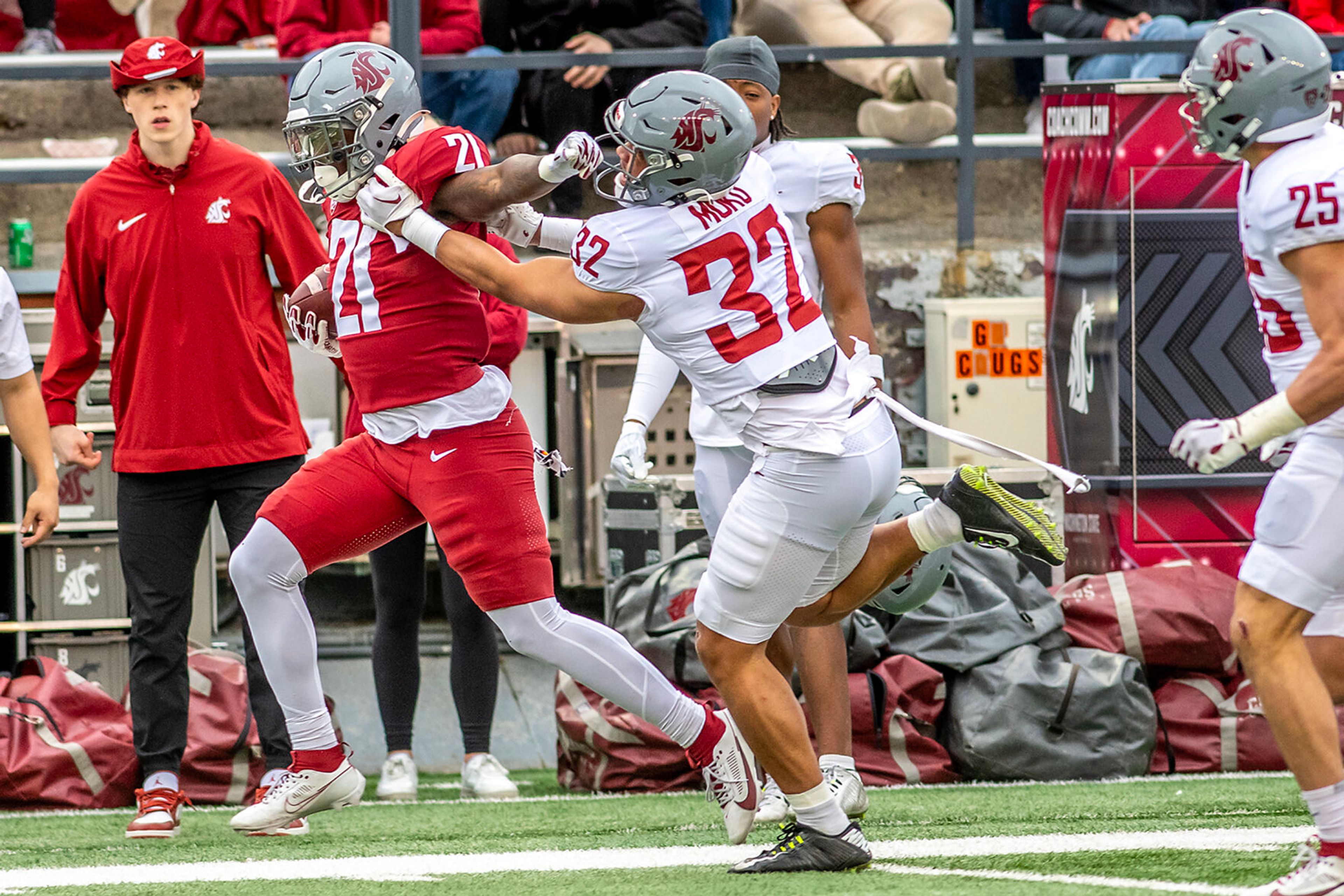 Crimson running back Wayshawn Parker stiff arms Gray defensive back Tanner Moku in a quarter of the Crimson and Gray Game at Washington State University in Pullman.