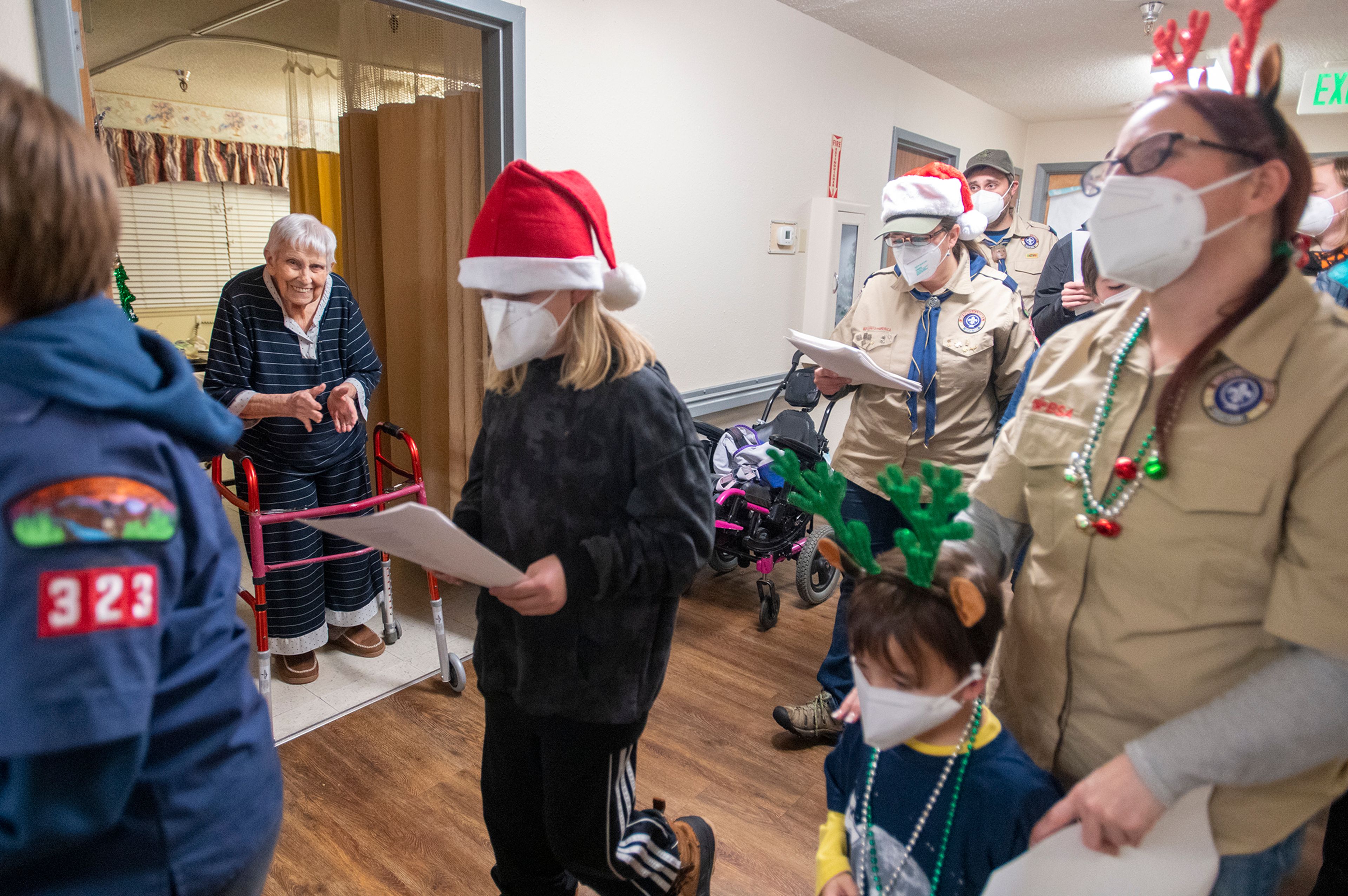 Resident Laura Rishling applauds Boy Scout carolers from Troop 345 and Pack 323 at Aspen Park of Cascadia in Moscow on Wednesday.