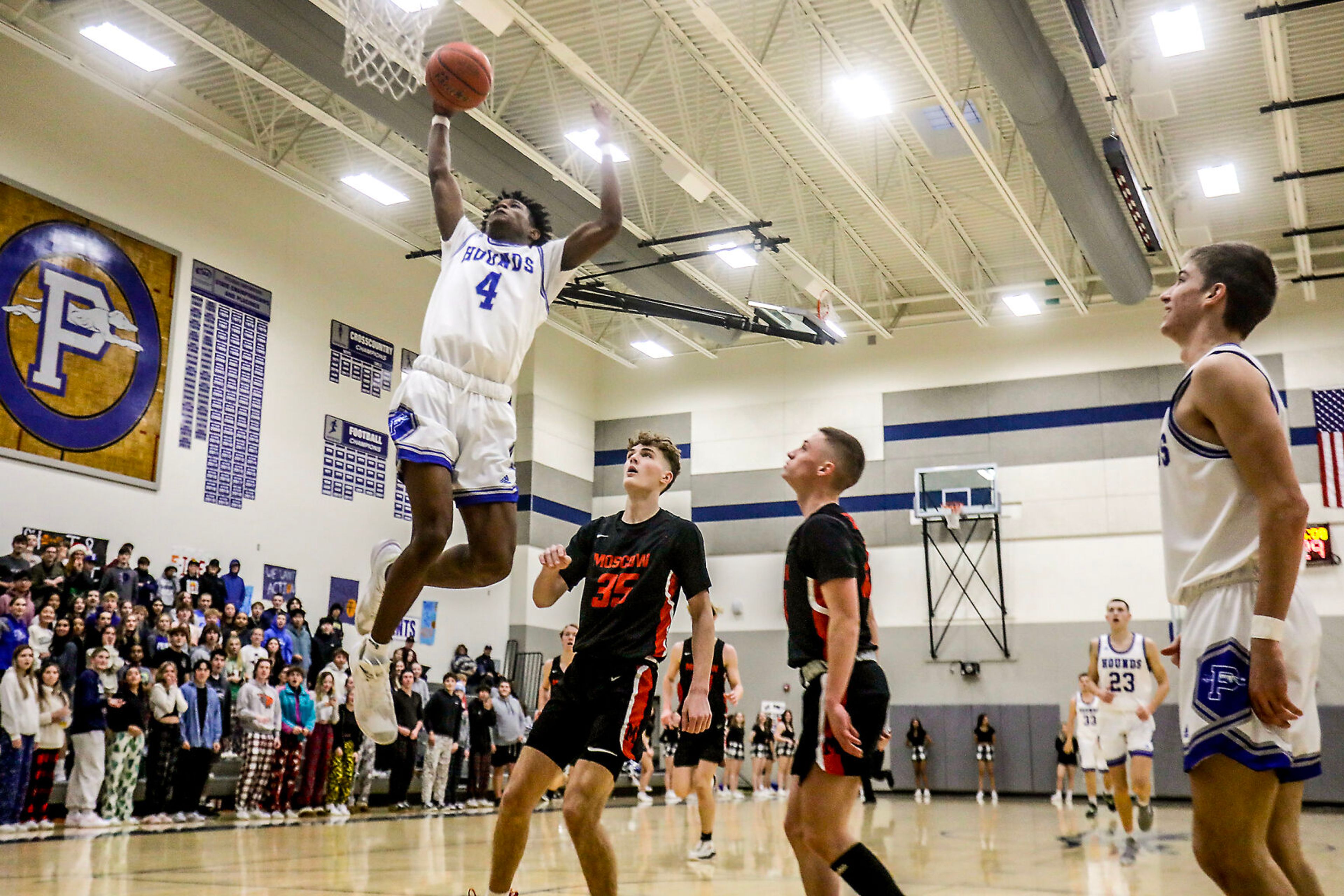 Pullman shooting guard Champ Powaukee, left, prepares to dunk the ball during Saturday’s nonleague boys basketball game against Moscow.