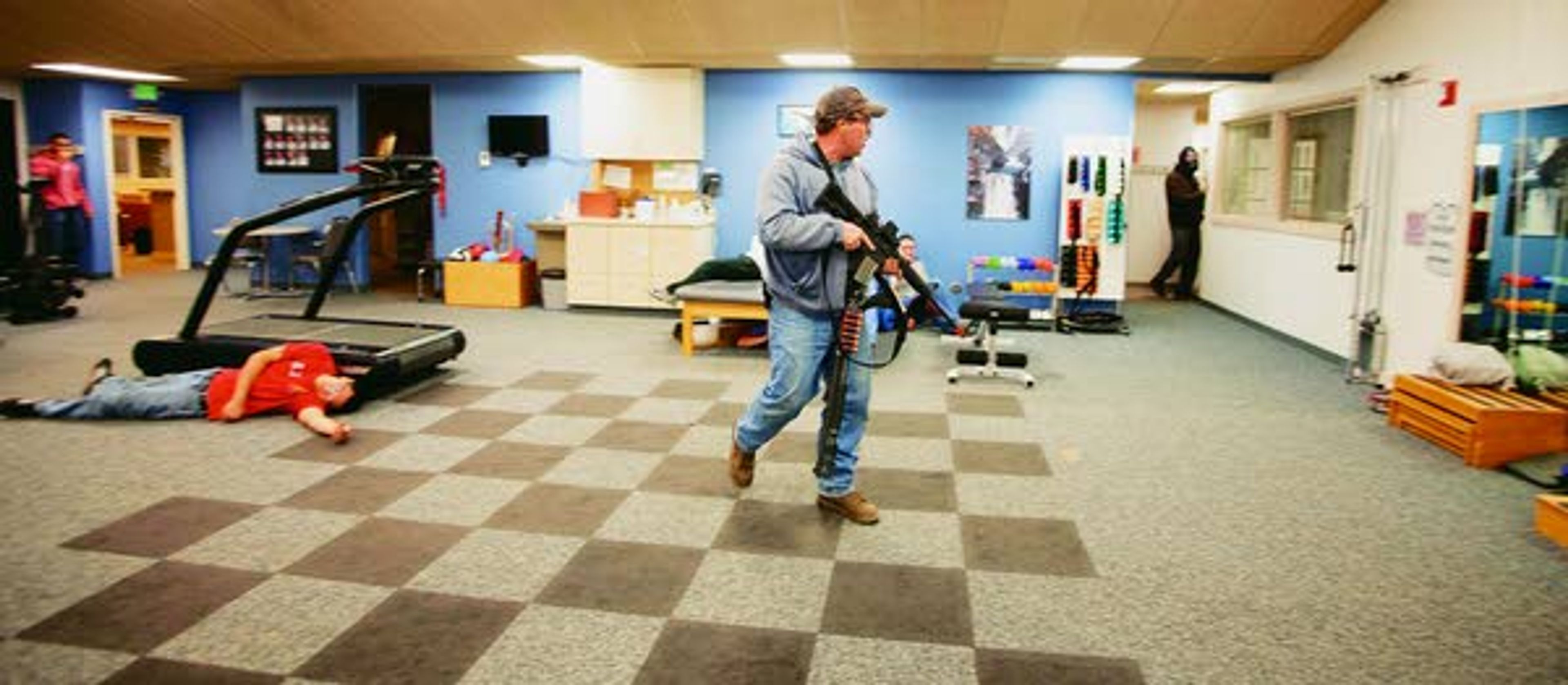 The "shooter," played by Pullman Police Department officer Aaron Breshears, center, wanders through the Summit Therapy exercise area during an active shooter response drill run by the PPD on Sunday at Summit Therapy in Pullman.