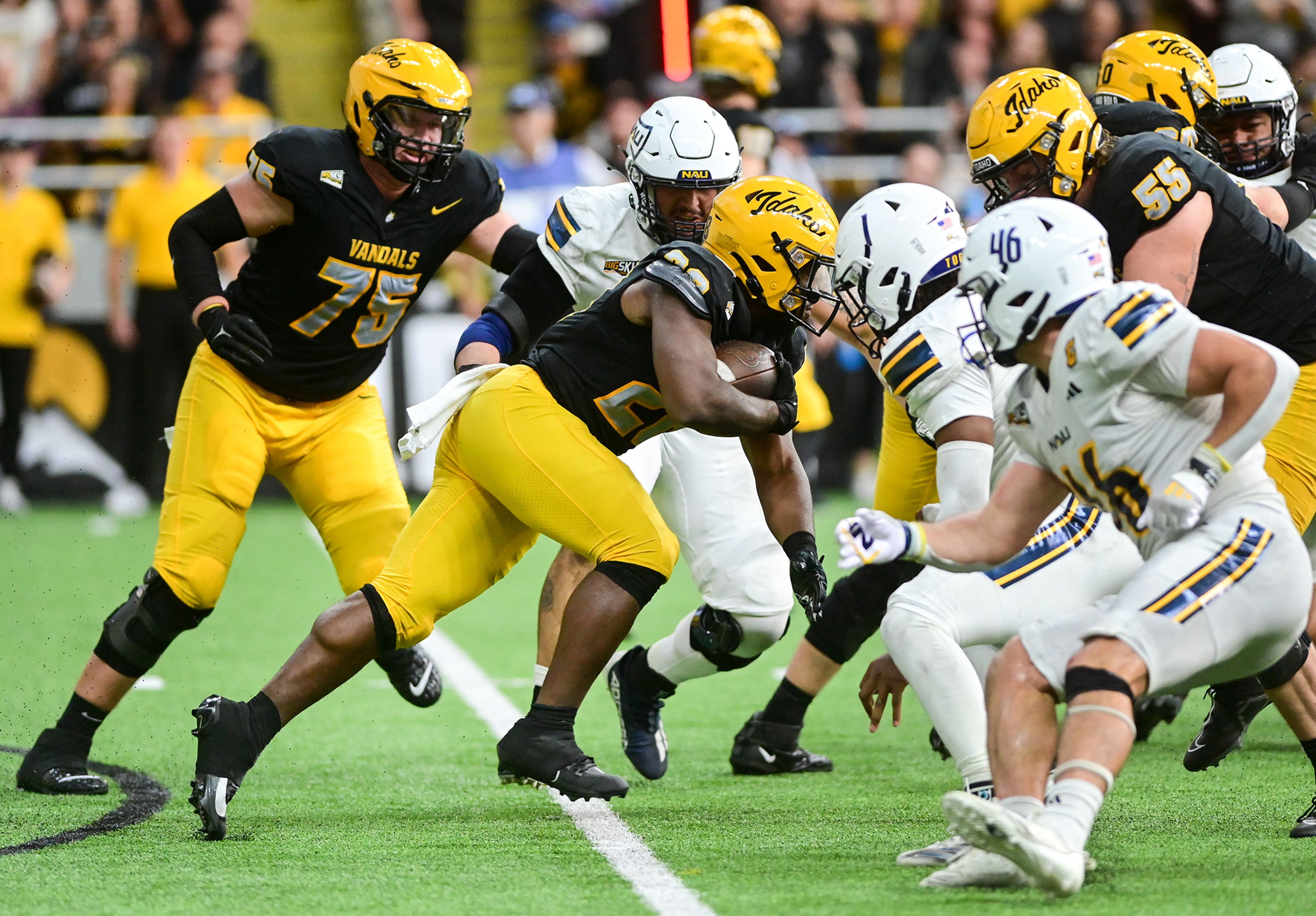 Idaho running back Nate Thomas carries the ball through Northern Arizona defenders Saturday at the P1FCU Kibbie Dome in Moscow.,