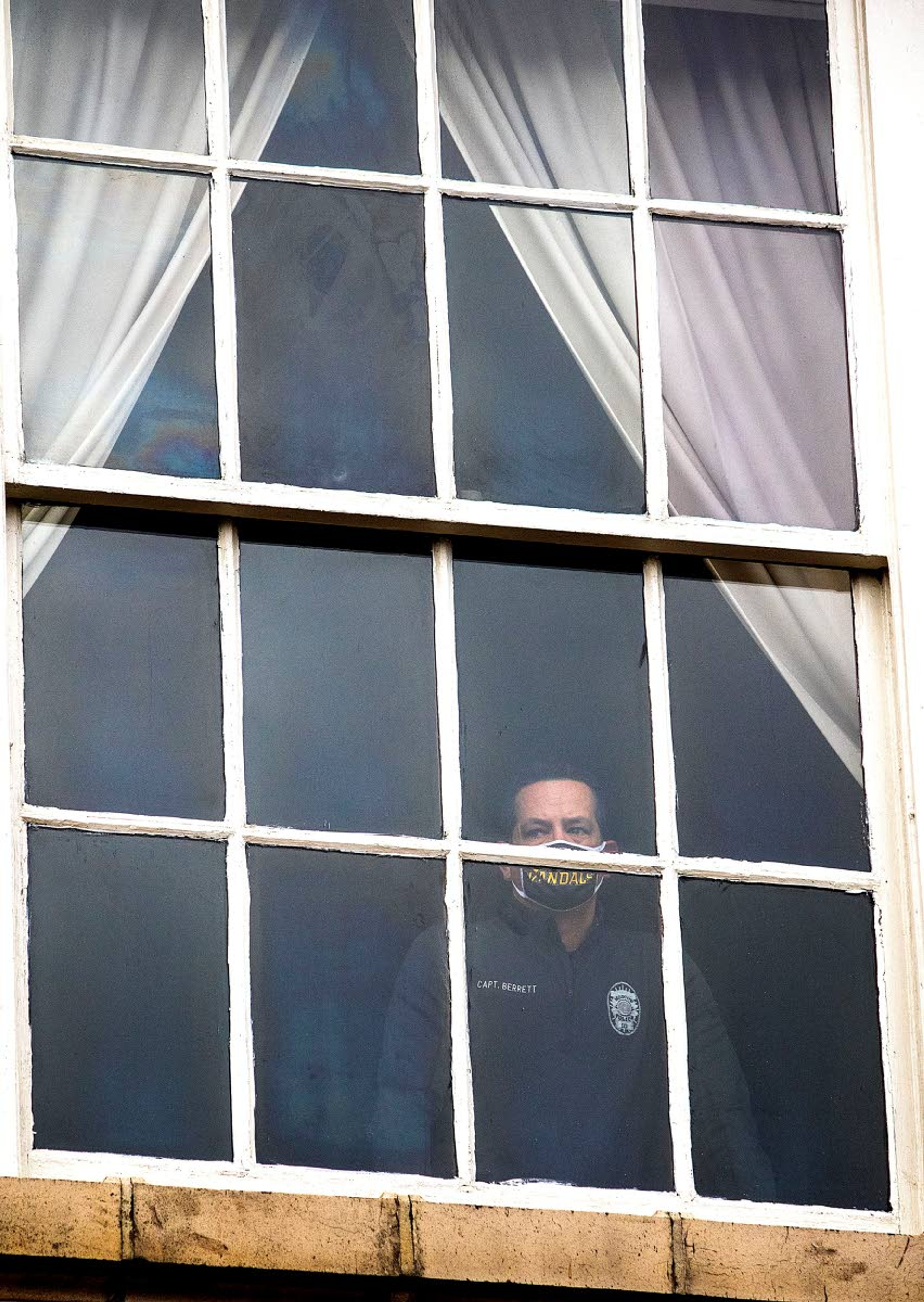 Moscow Police Capt. Tyson Berrett observes a church singing event from a window in Moscow City Hall in September.