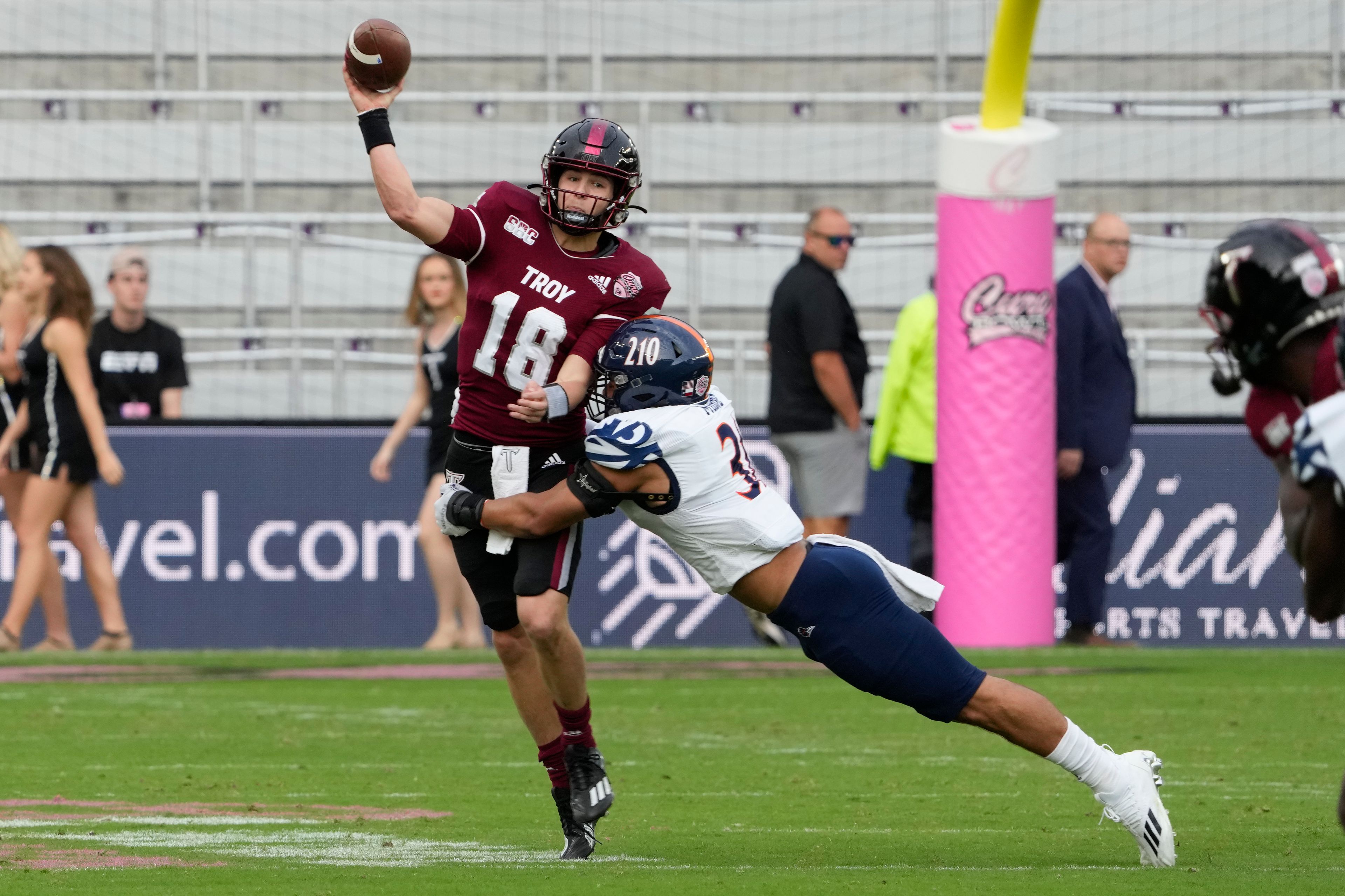 Troy quarterback Gunnar Watson (18) releases the ball as he is hit by UTSA linebacker Trey Moore during the first half of the Cure Bowl NCAA college football game, Friday, Dec. 16, 2022, in Orlando, Fla. (AP Photo/John Raoux)