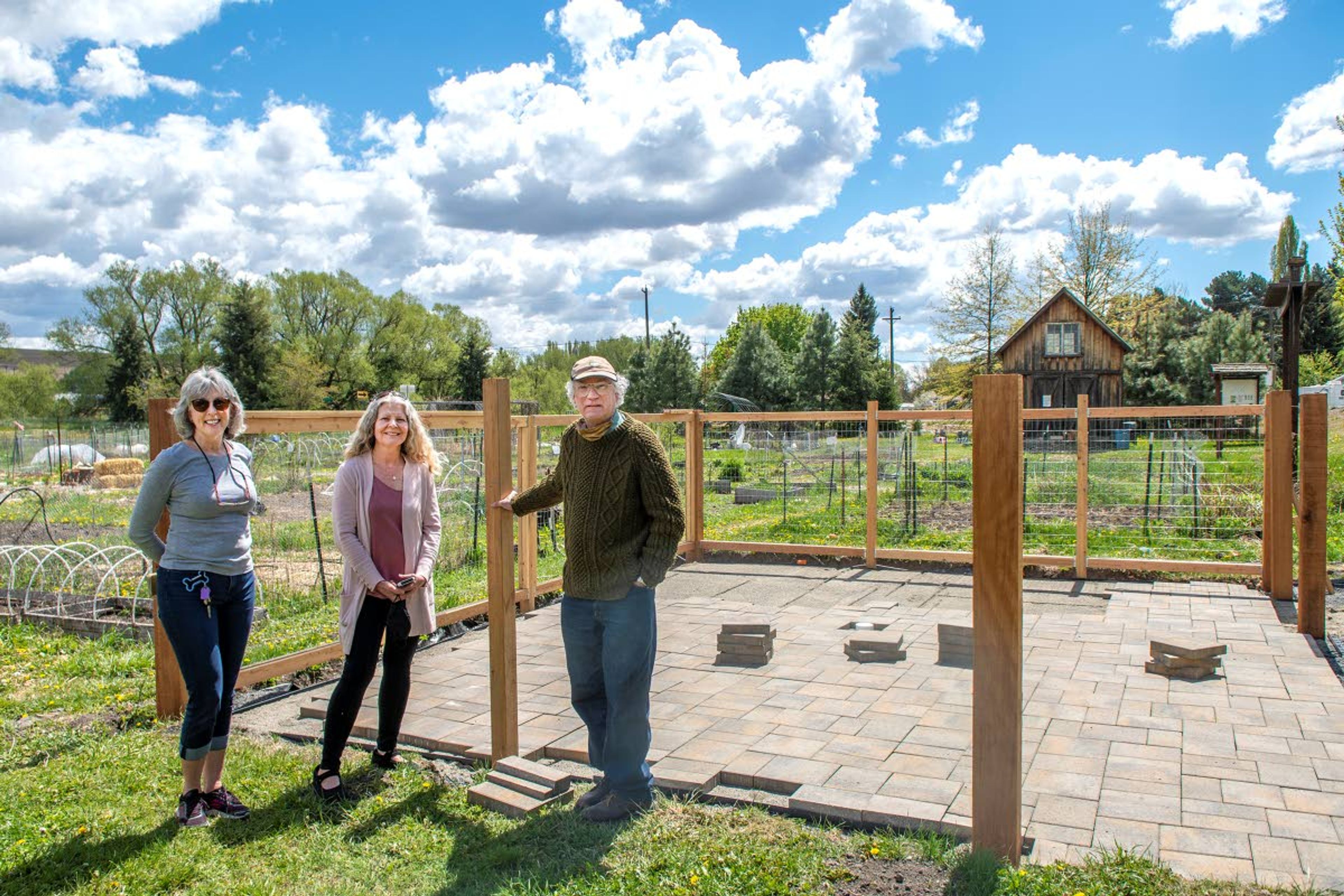 Vicki Leeper, a marketing specialist with Disability Action Center Northwest, from left to right, stands next to Becky Phillips and Tim Paulitz, both board members on the Pullman Community Garden council, in front of a 20-by-25-foot garden plot that will be easily accessible for at least two disabled or handicapped gardeners upon completion. Everyone in this image has been fully vaccinated.